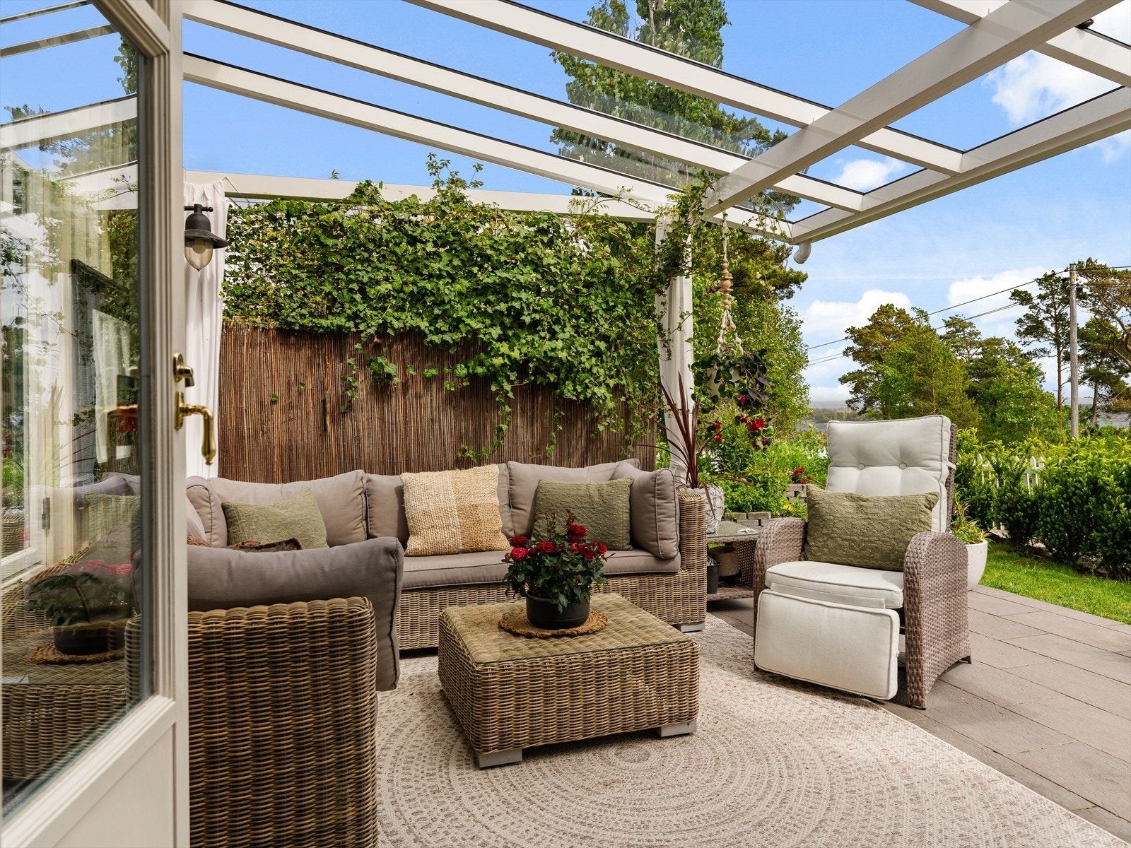 Fra stuen er det utgang til flislagt uteområde, som også har overbygg i glass. Her er det god plass til større lounge-gruppe. Galleribilde