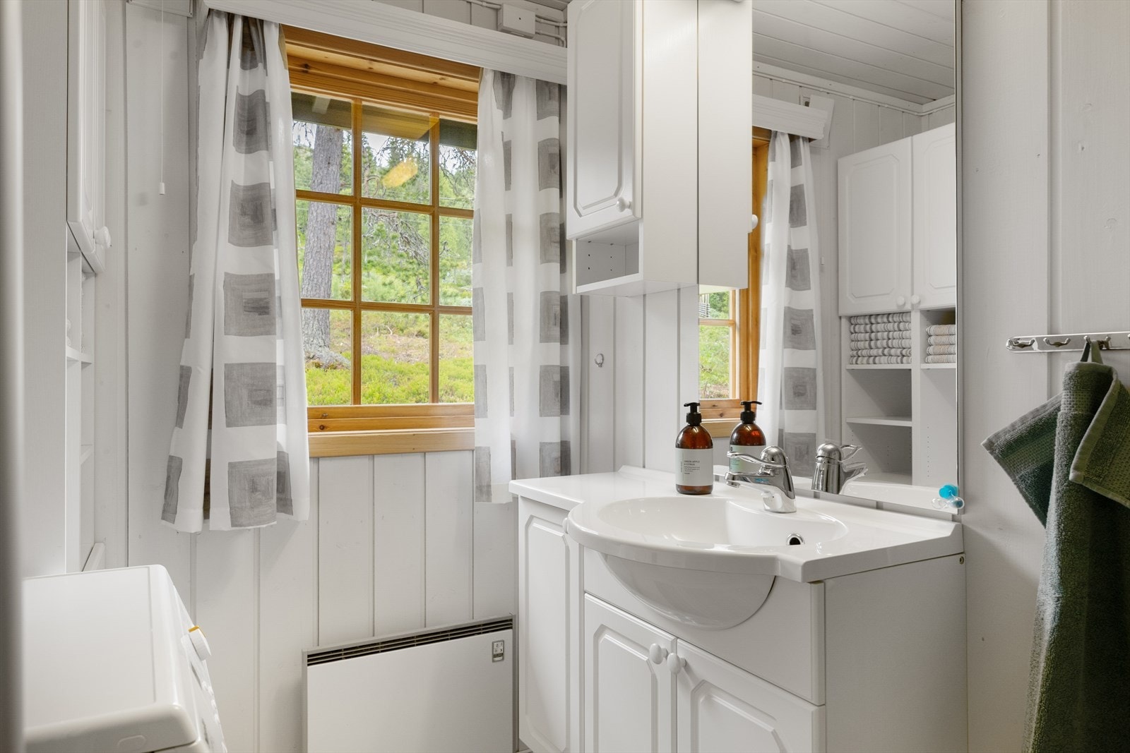 Lyse panelvegger og lyst gulvbelegg gir baderommet et rent og enkelt uttrykk. Galleribilde