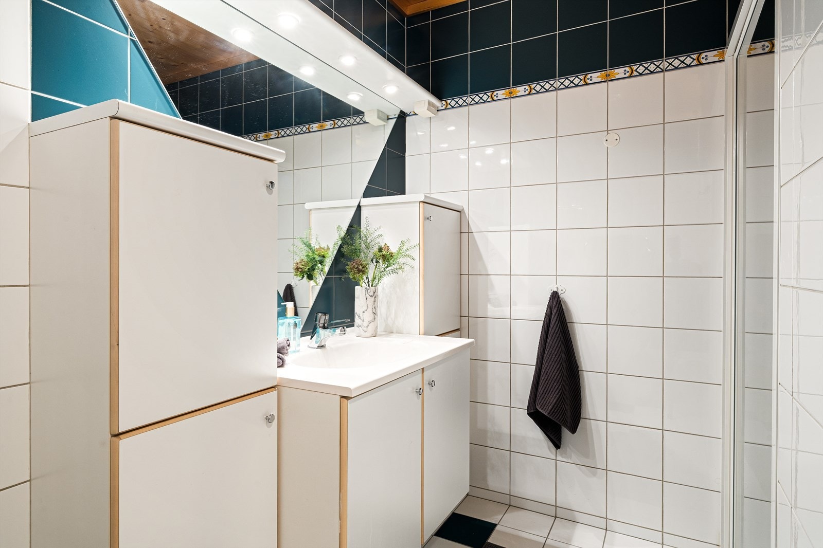 Badet er innredet med dusjnisje, servantskap, speil, 3 skap og elektrisk håndkletørker Galleribilde