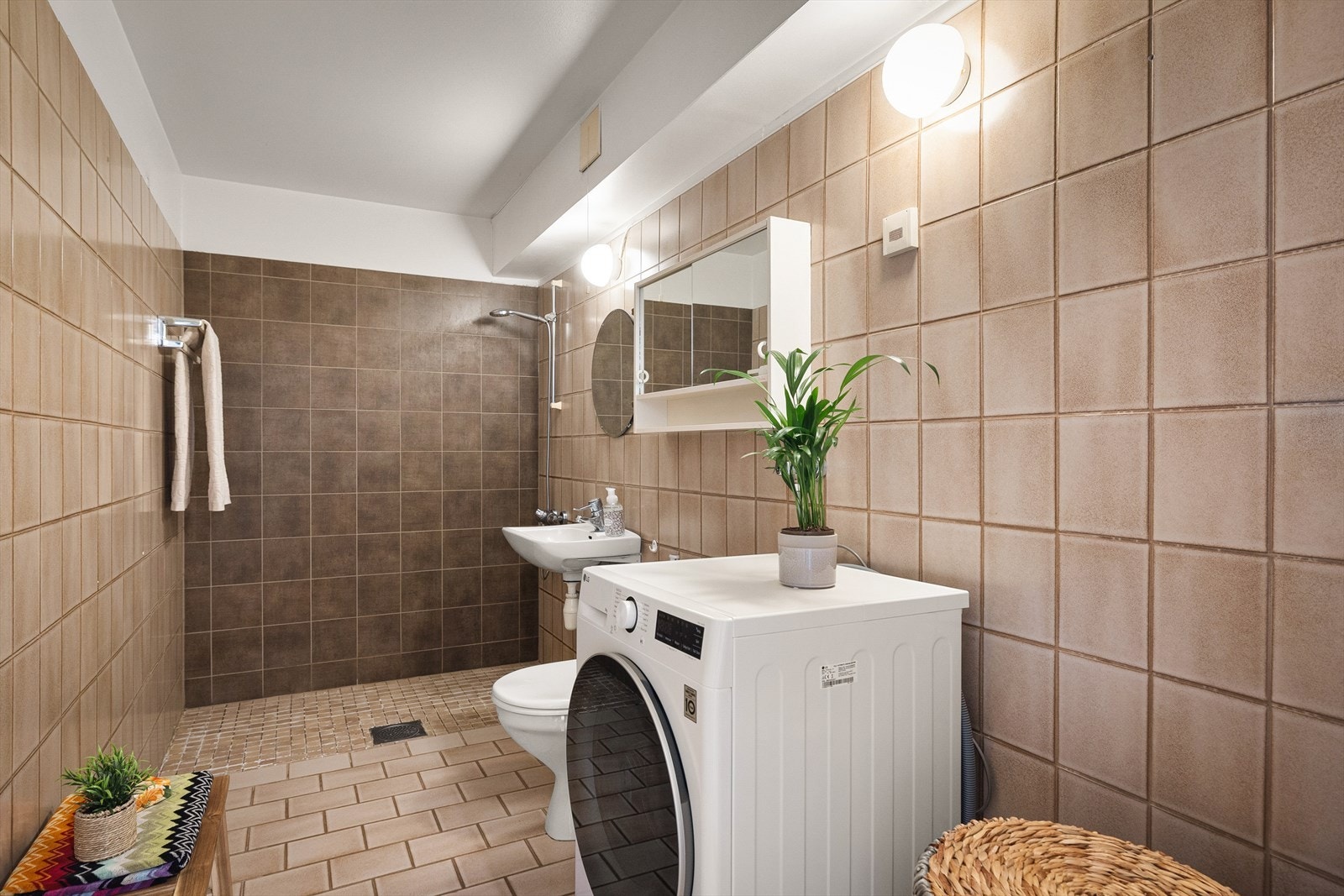 Badet er av eldre standard, men romslig og funksjonelt med flislagte overflater og gulvvarme. Galleribilde