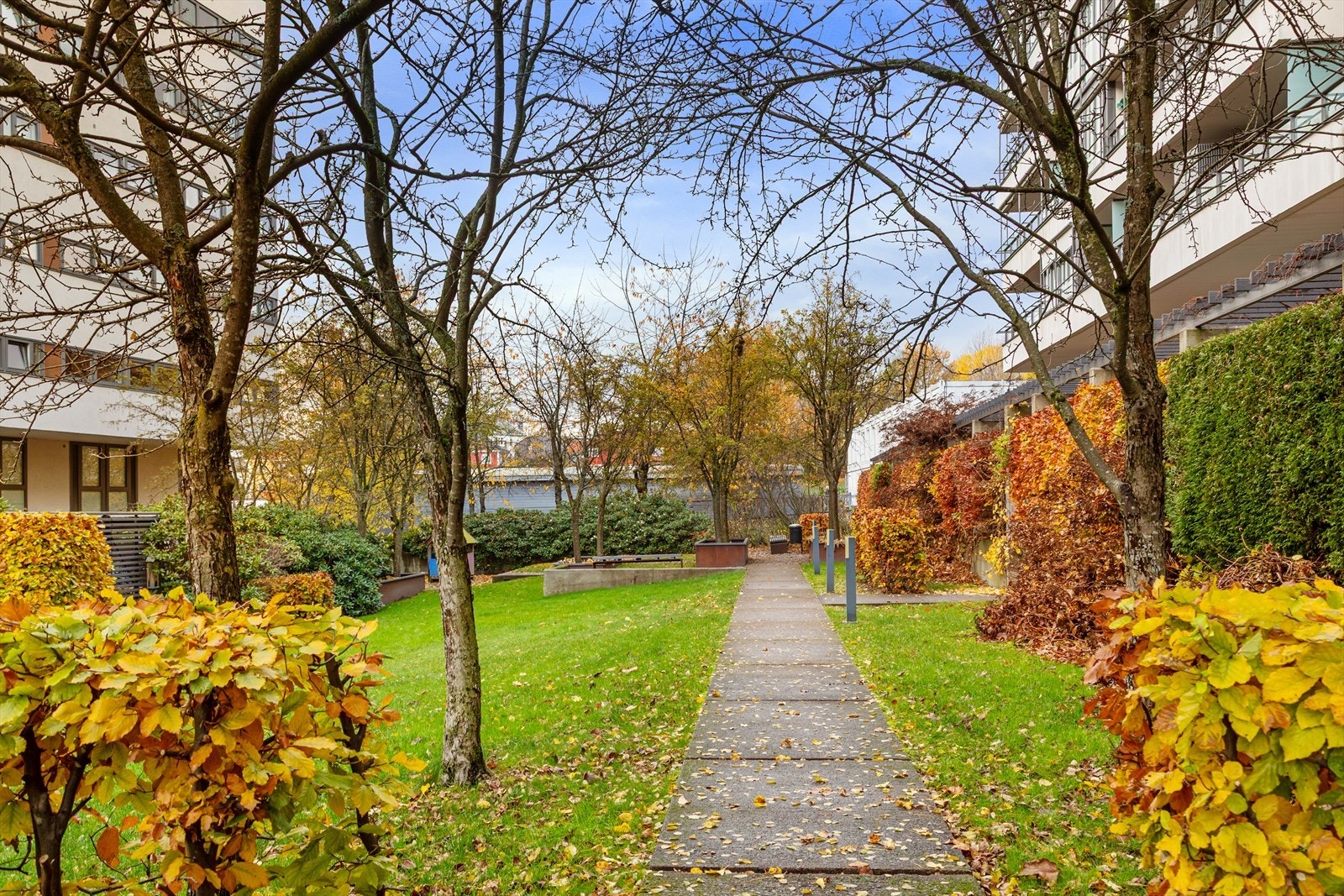 Pent opparbeidet uteområde med lekeplass og sittebenker Galleribilde