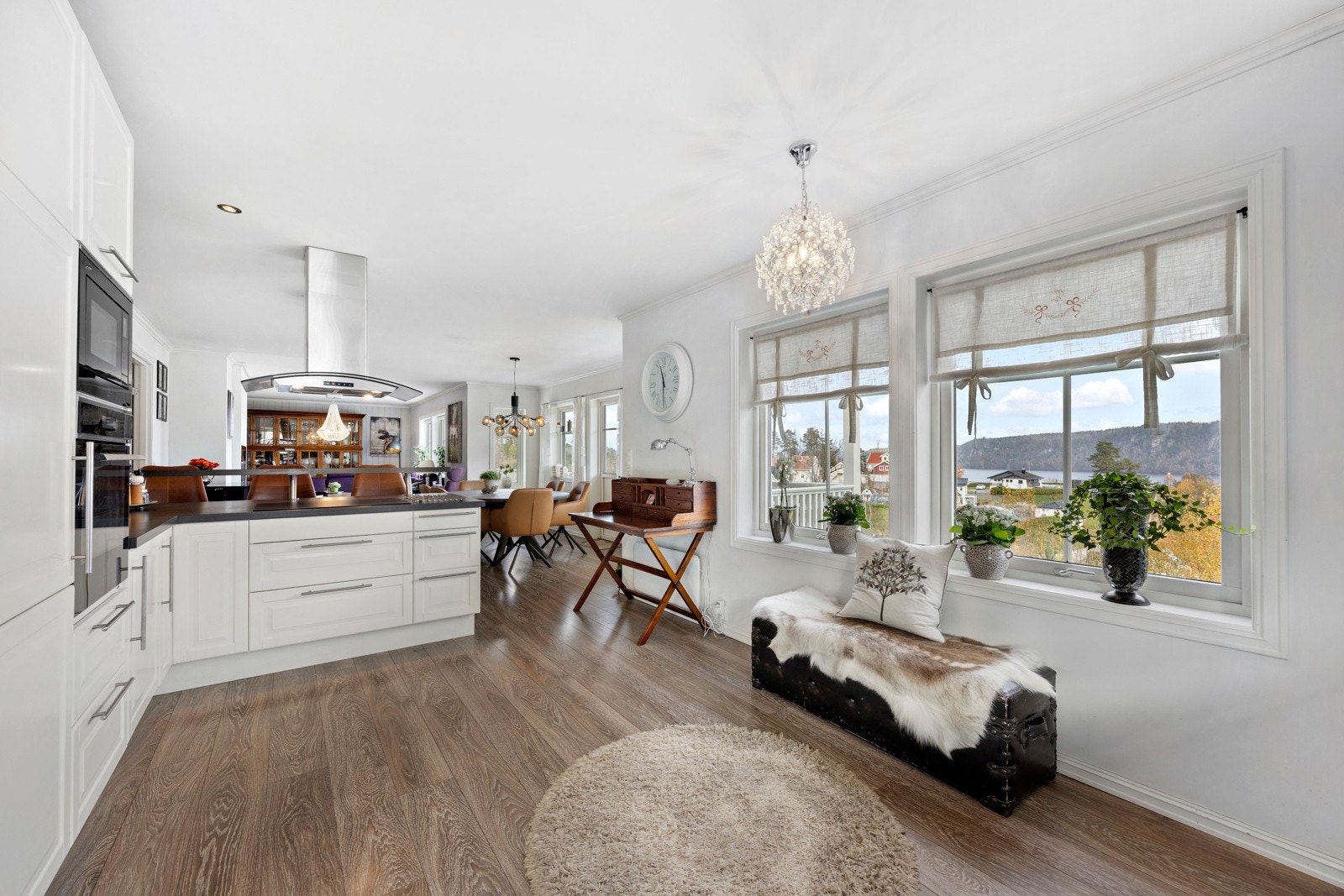 Kjøkkenet er lyst og innbydende, med lyse profilerte fronter, mørk benkeplate og integrerte hvitevarer. Den åpne løsningen skaper en sosial atmosfære og gir plass til både matlaging og hyggelige måltider. Galleribilde