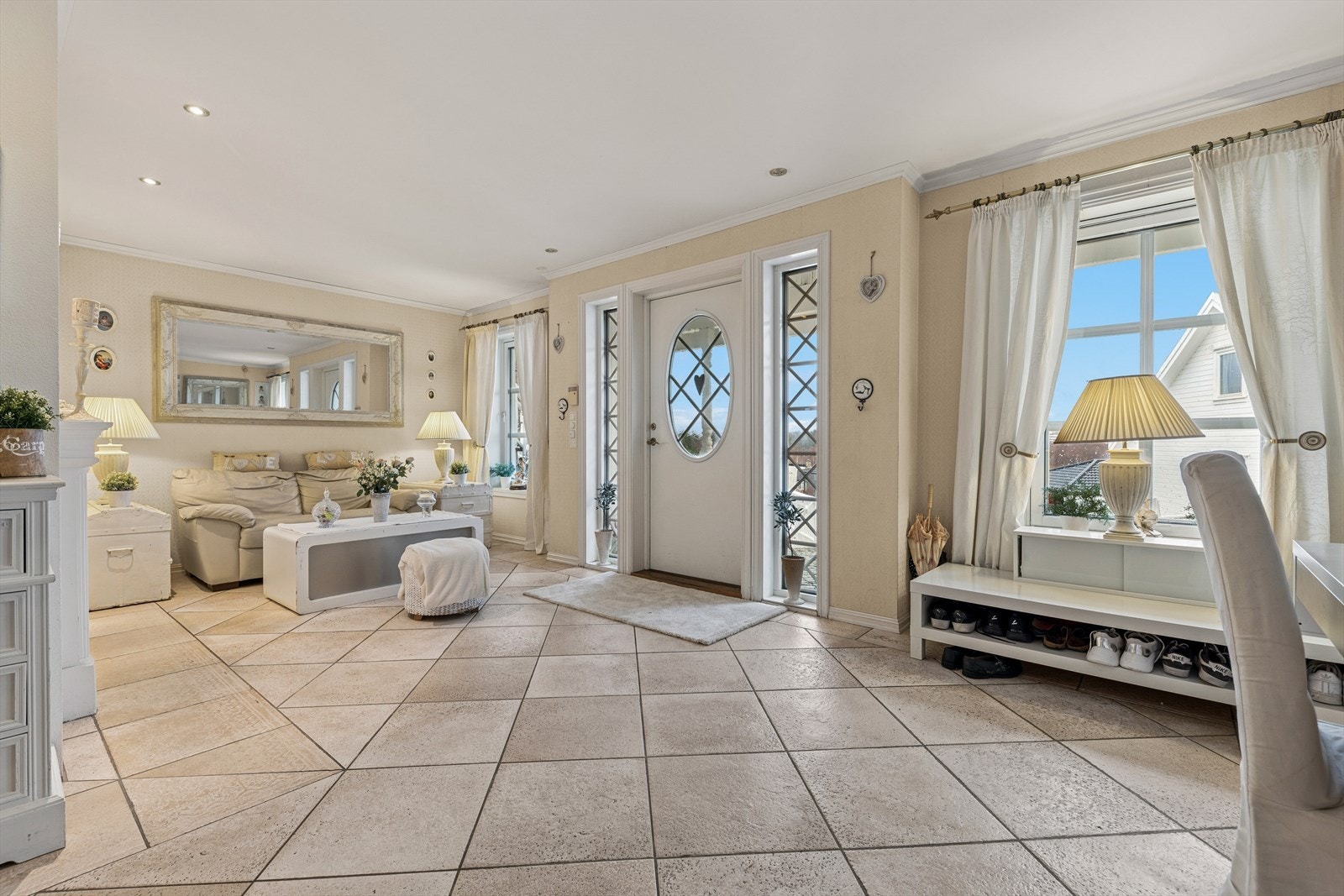 En lys og virkelig romslig flislagt entré ønsker deg velkommen inn. Her er det god plass til oppbevaringsløsninger og annet møblement. Galleribilde