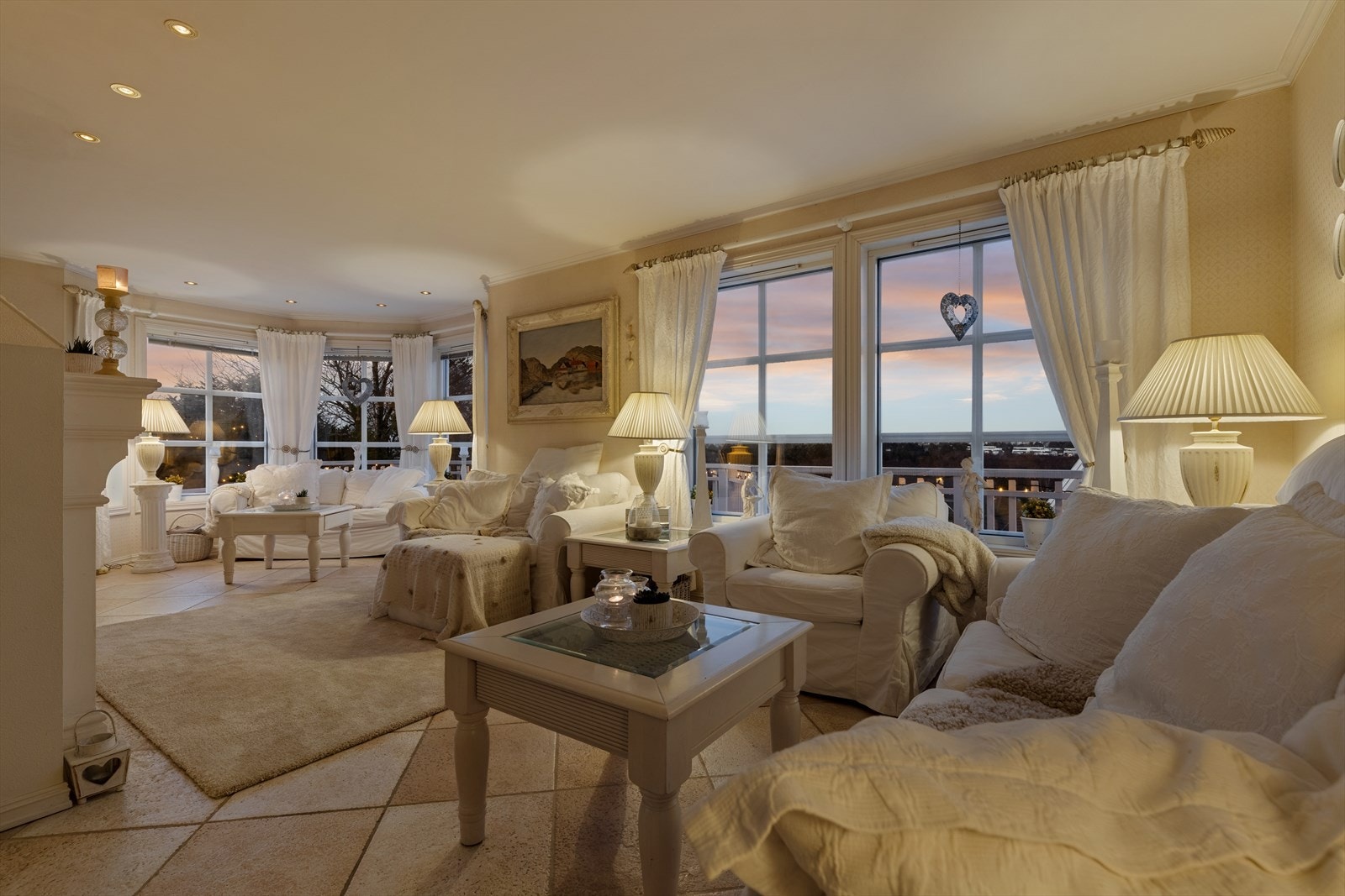 Stuen har store vinduer slipper inn naturlig lys og gir utsikt mot en vakker kveldshimmel. Galleribilde