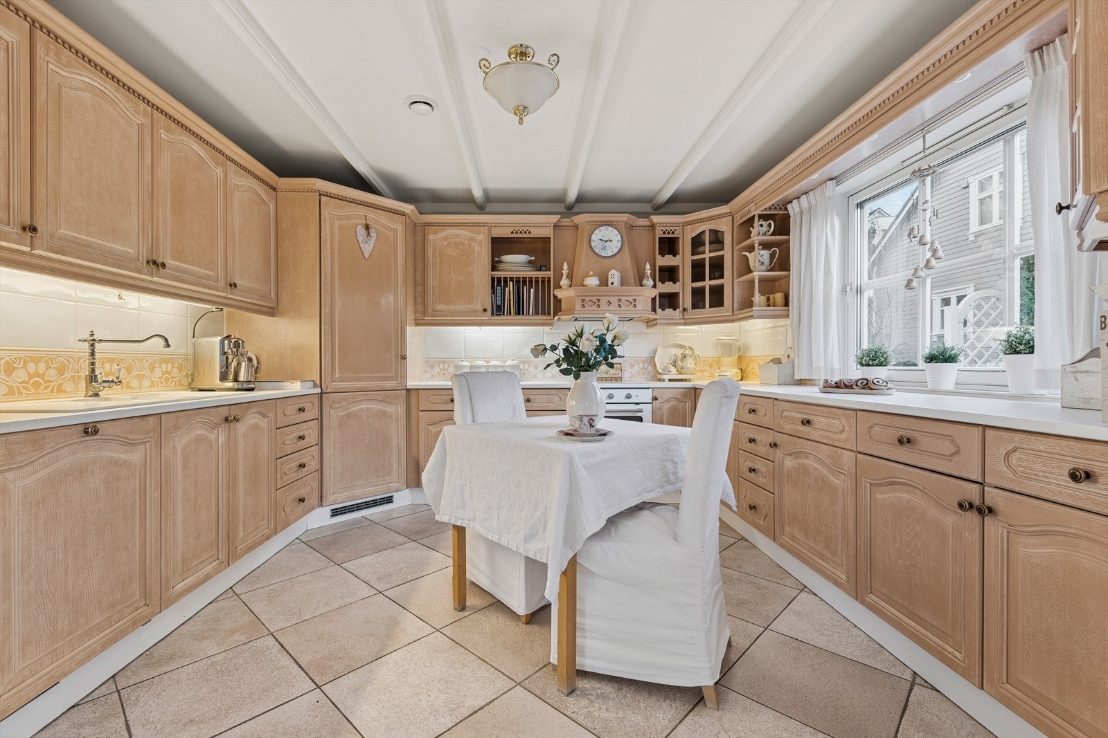 Innredningen har profilerte fronter i lyst treverk og hvite benkeplater i fin kontrast. Galleribilde