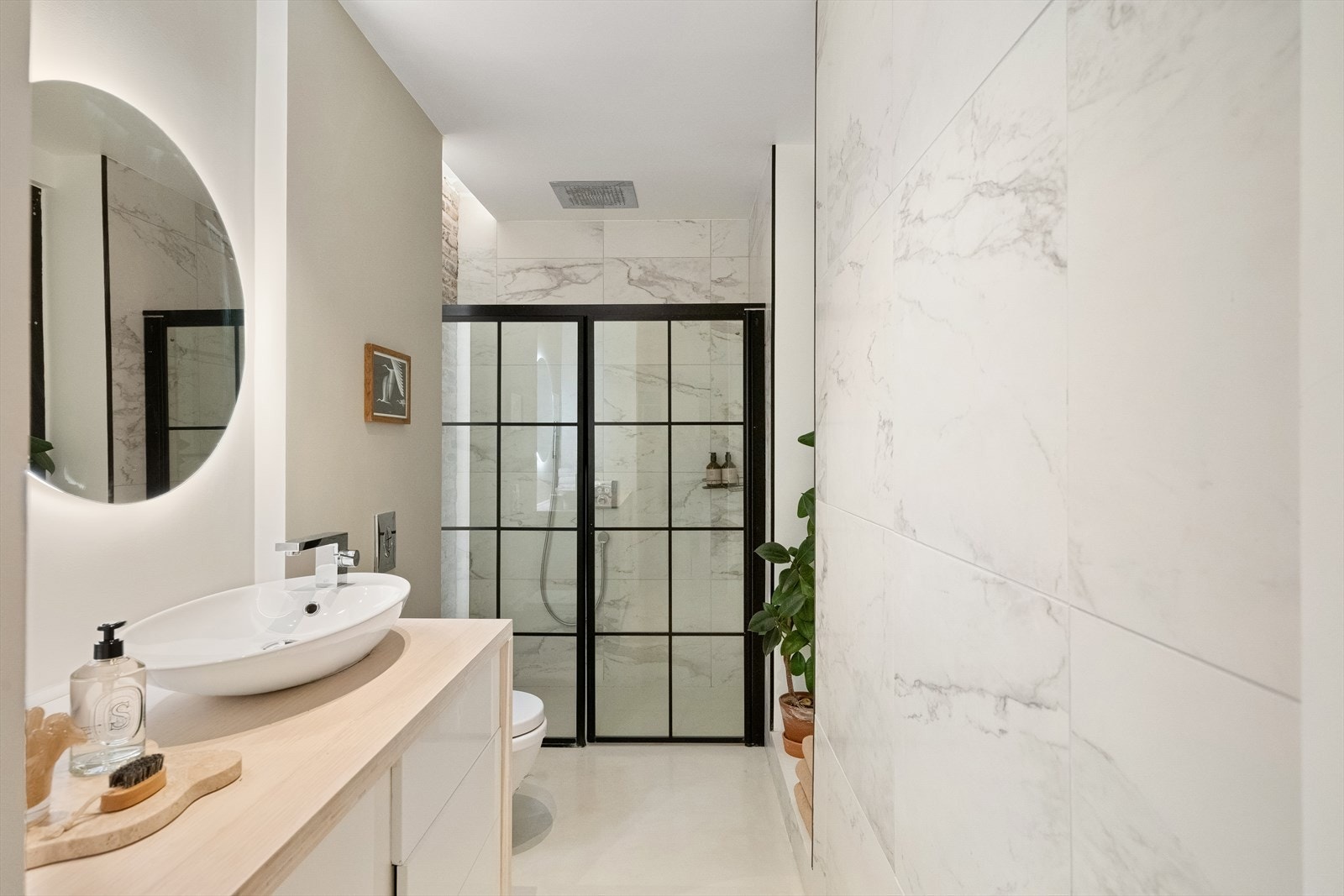 Videre er det vegghengt toalett, romslig dusjsone med innebygget regnfallsdusj og dusjarmatur på vegg. Badet har gulvvarme og opplegg for vaskemaskin. Galleribilde