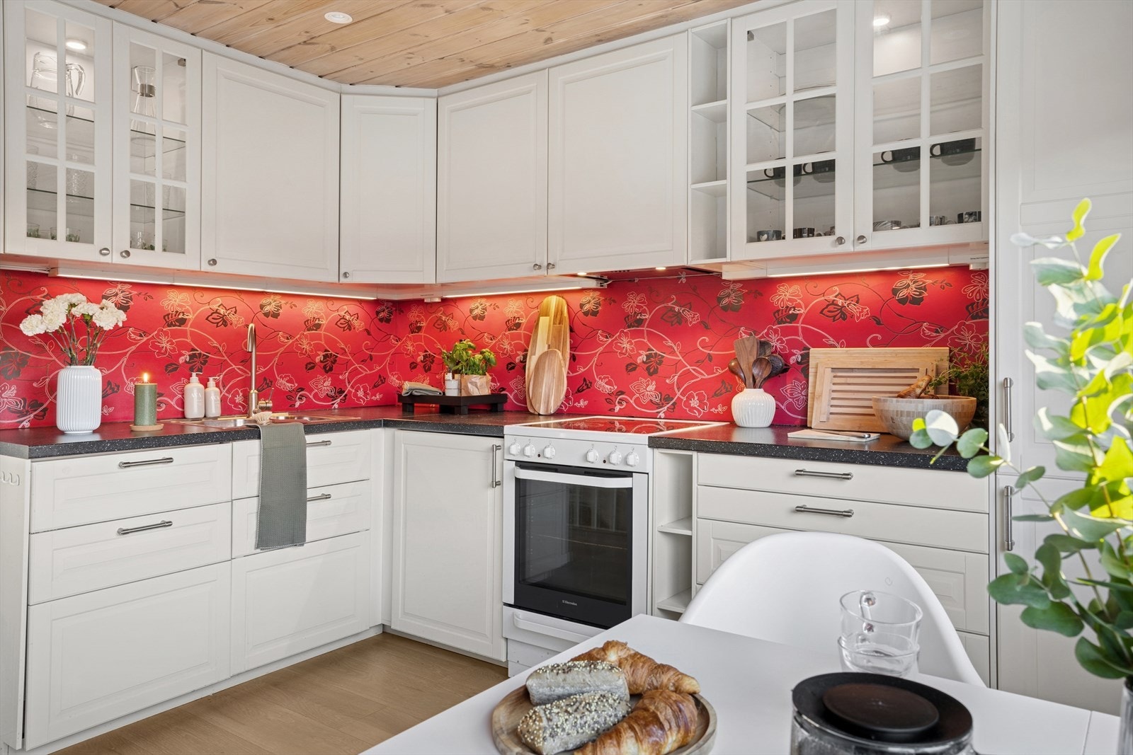 Kjøkkenet er innredet med folierte skrog med profilerte fronter og laminert benkeplate. Frittstående komfyr. Galleribilde