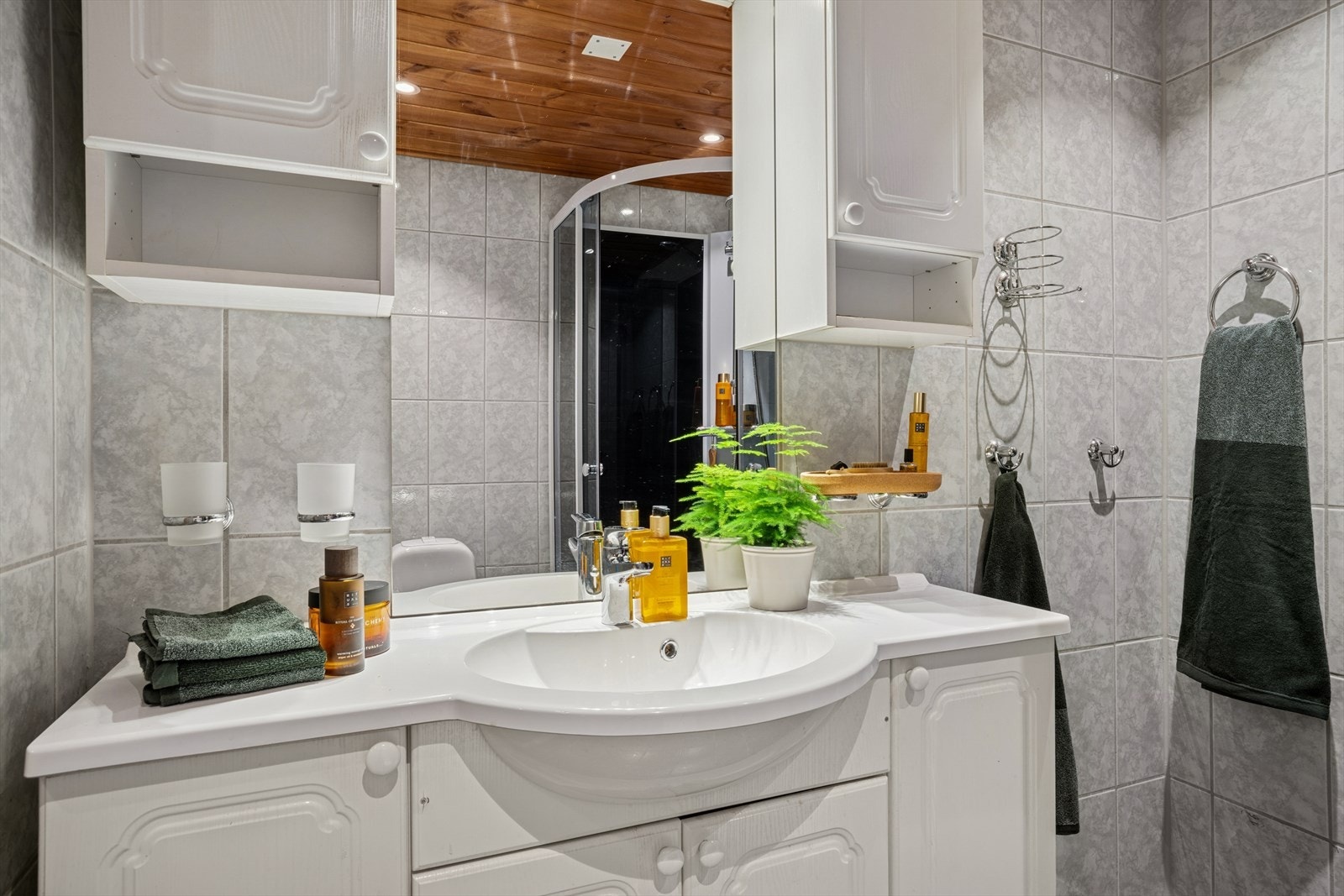 Badet er innredet med dusjkabinett, gulvmontert toalett og servant. Galleribilde