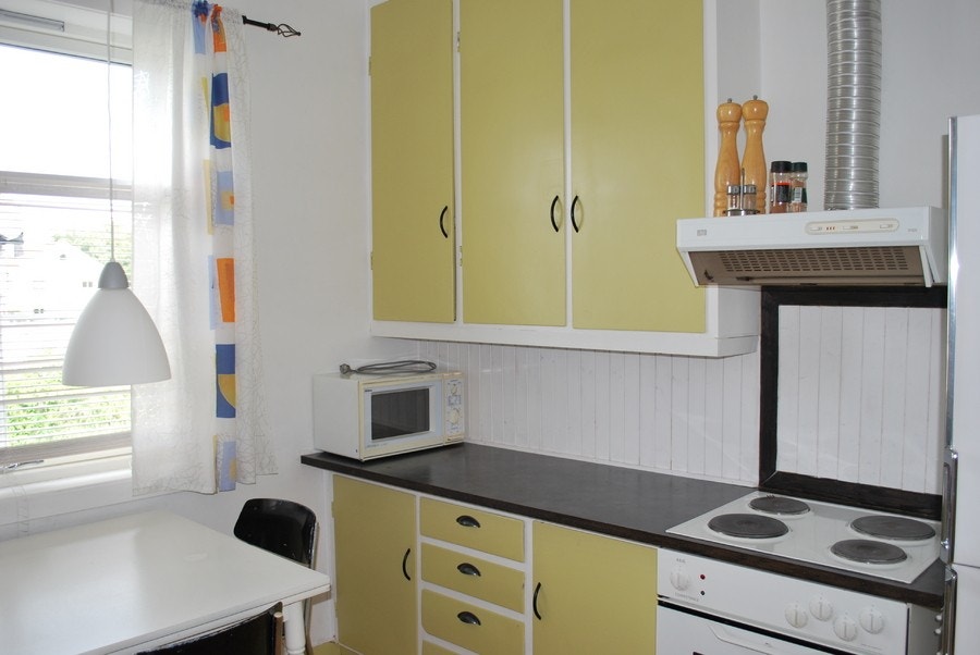 Kjøkken med mye skapplass, stekovn og vifte samt kjøleskap og frys Galleribilde