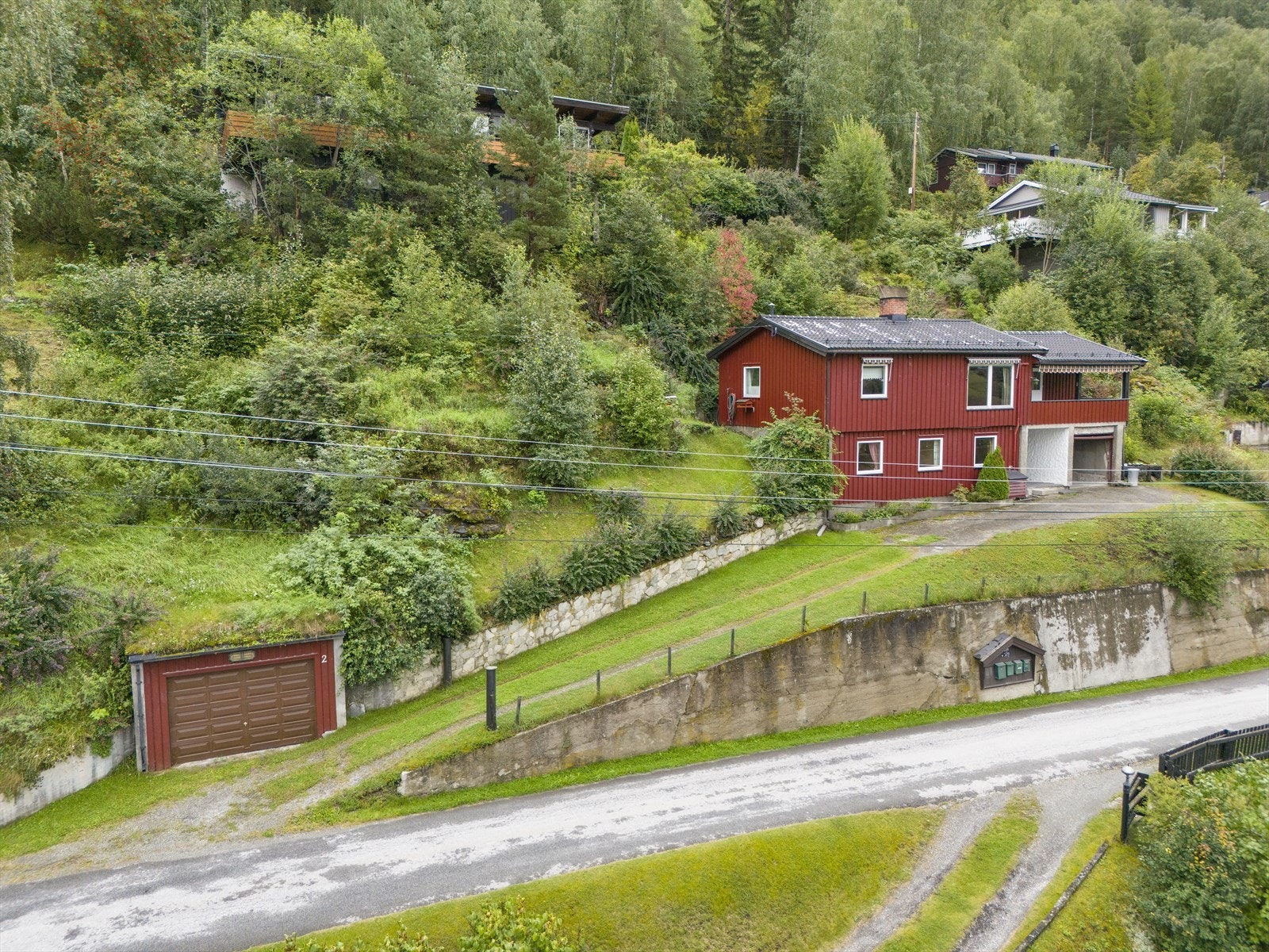 Det er og to garasjer på eiendommen, en ved veien og en i underetasjen på boligen. Galleribilde
