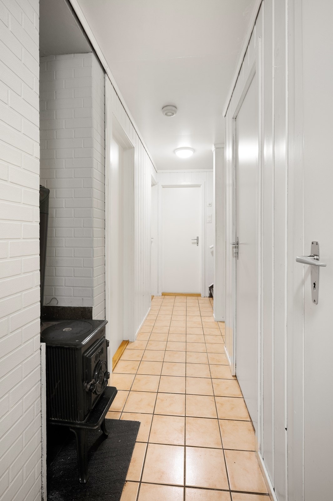 Gang med vedovn i underetasjen. Galleribilde