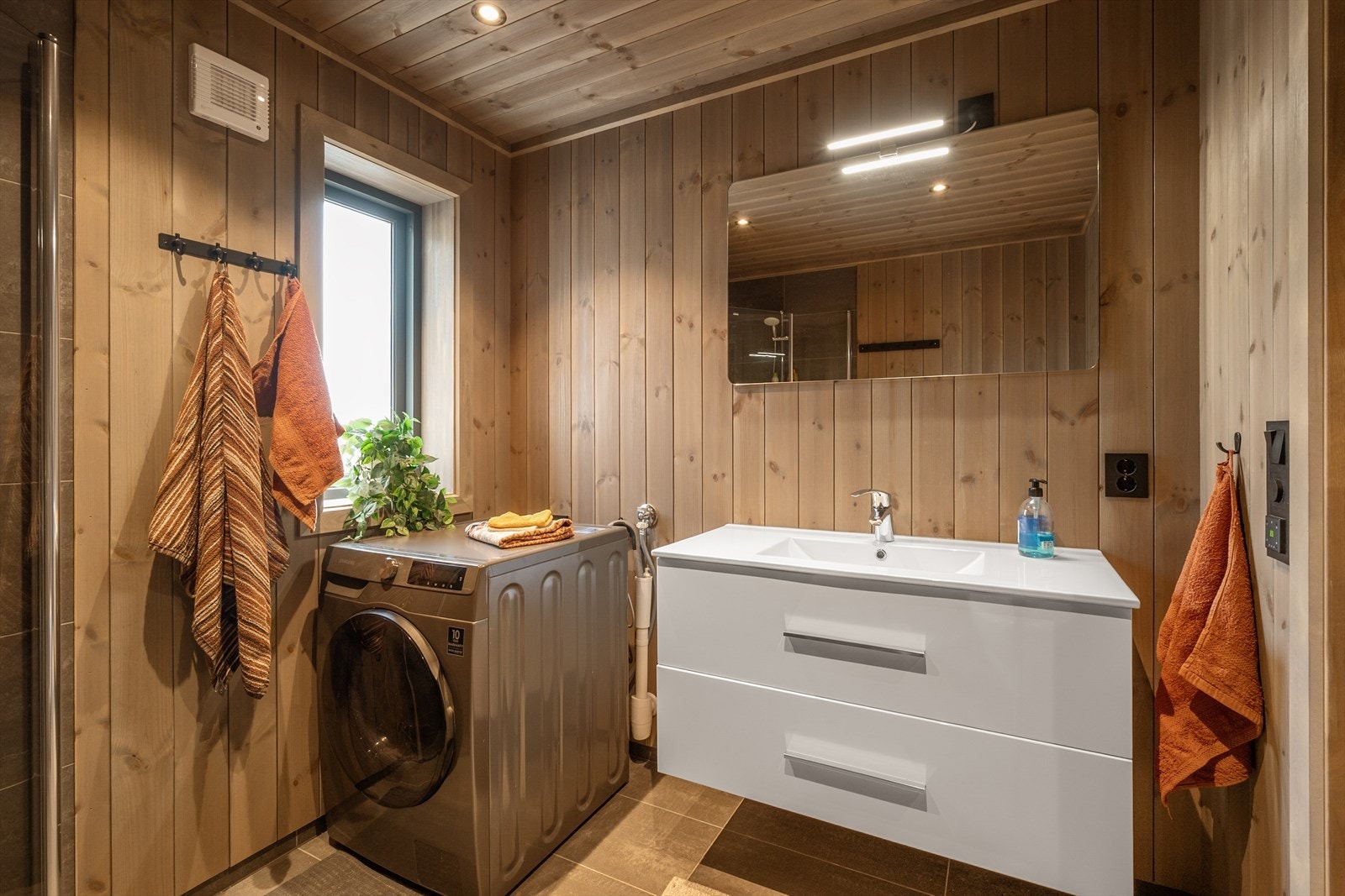 Badet er lunt og innbydende m/flislagt gulv og gulvvarme, og flislagt dusjsone. Galleribilde