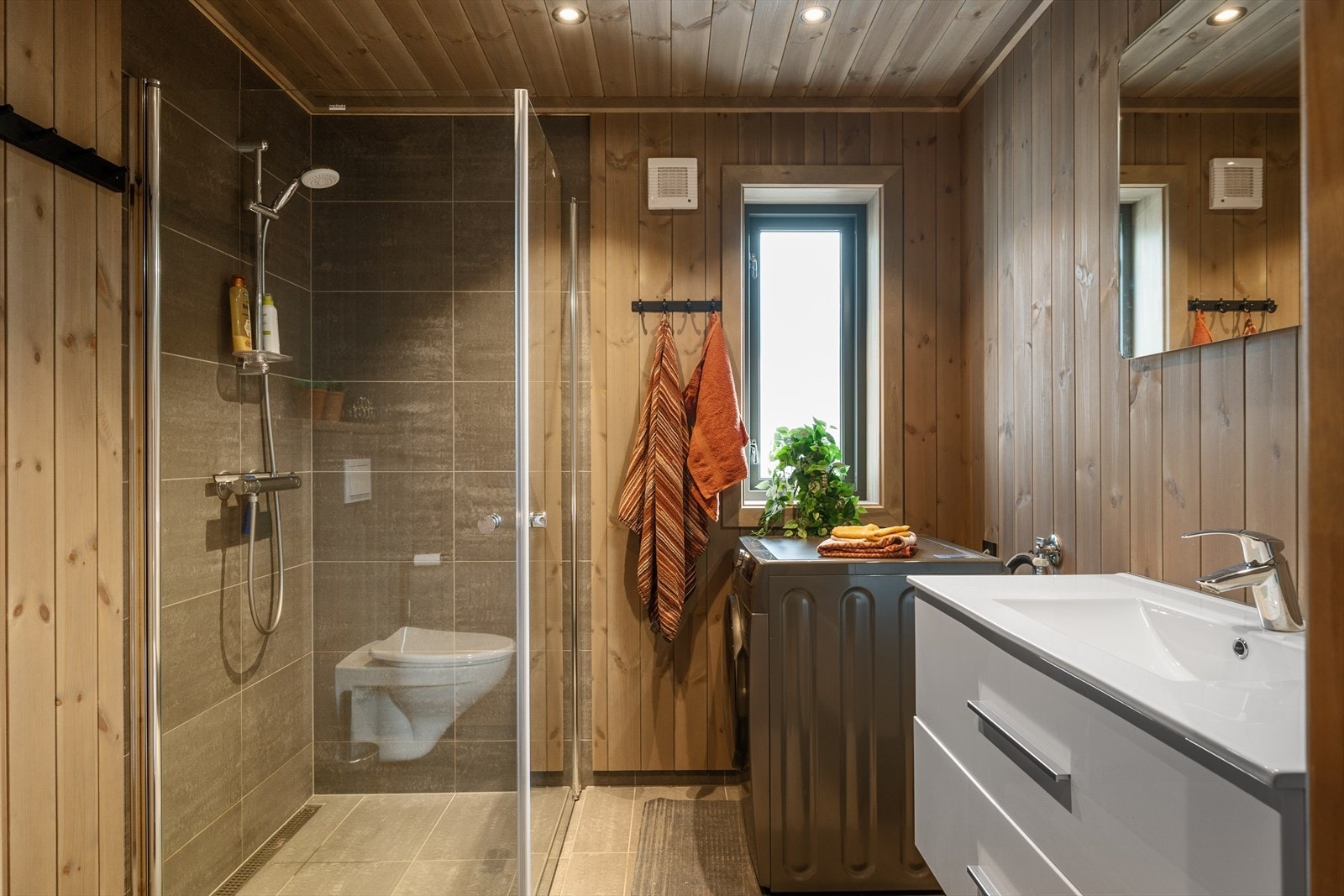 Interiøret består av lys skuffeinnredning og speil m/belysning, dusjvegger samt vegghengt wc. I tillegg opplegg for vaskemaskin. Galleribilde