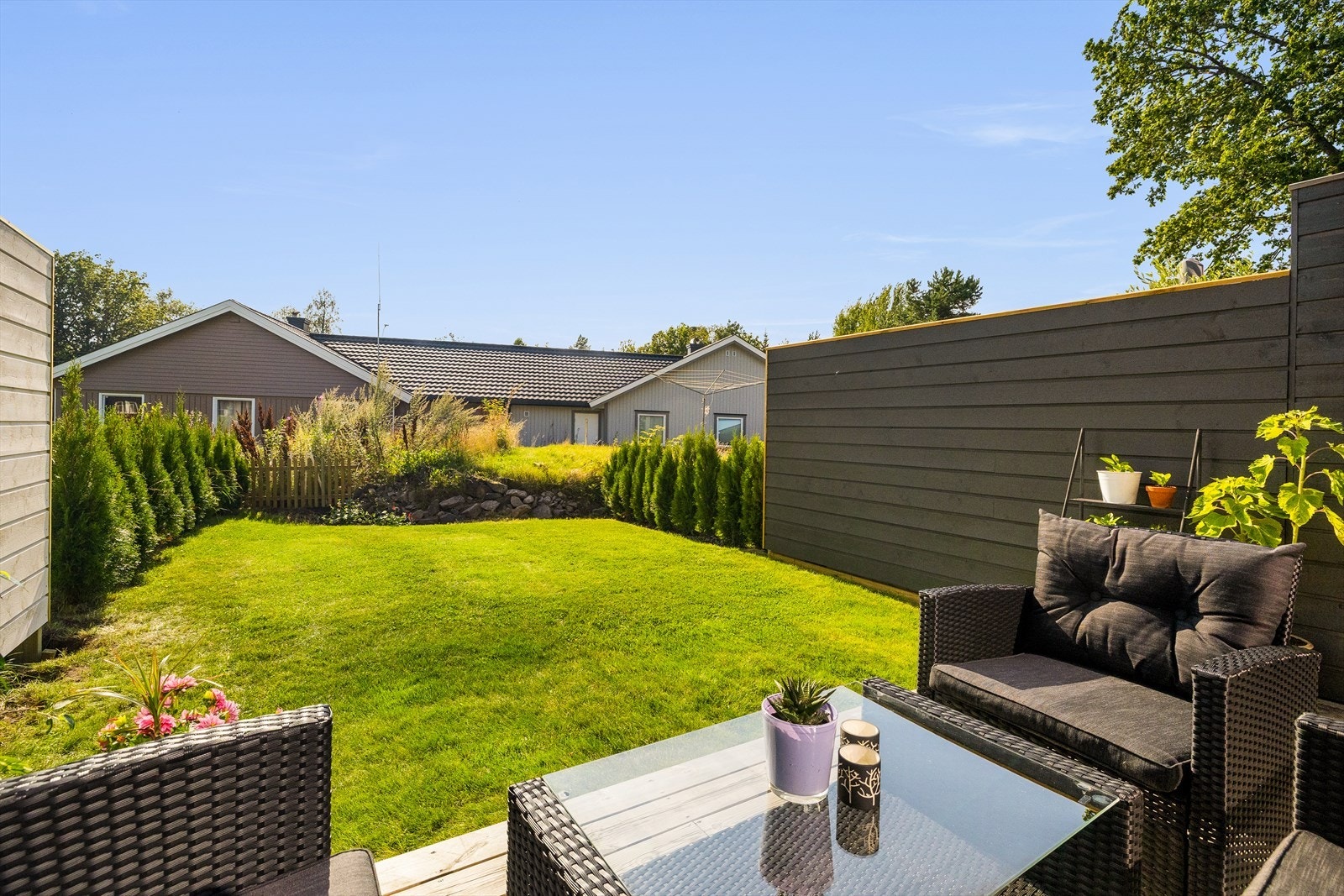 Uteplassen har utsikt over et rolig nabolag, og den flate plenen rundt terrassen gir muligheter for lek og aktiviteter. Galleribilde