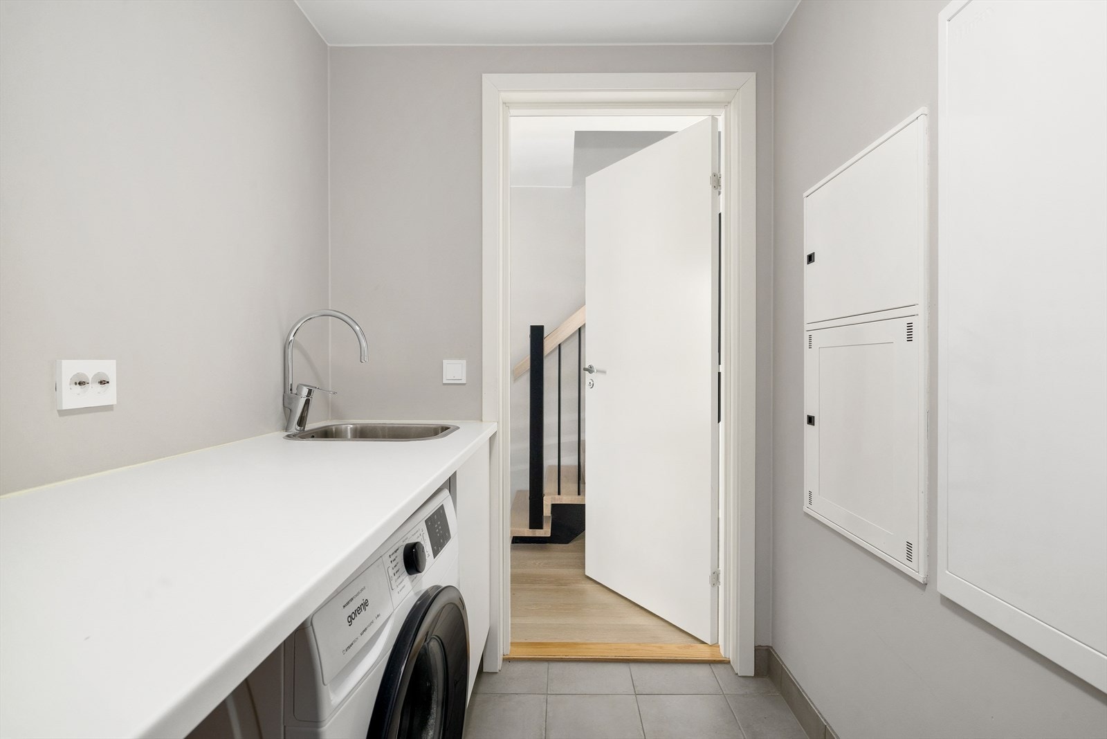 Vaskerom / teknisk rom. Innredet med benk og opplegg for vaskemaskin og tørketrommel. Galleribilde