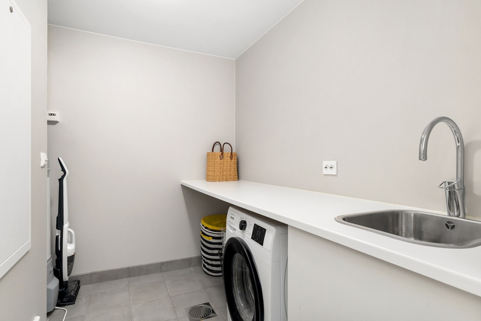 Vaskerom / teknisk rom. Innredet med benk og opplegg for vaskemaskin og tørketrommel. Galleribilde