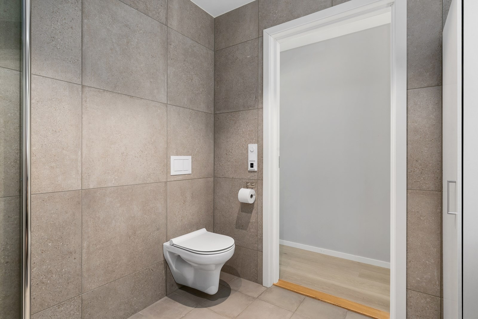 Delikat bad hvor veggene og gulvet er kledd med store, grå fliser(fra Modena) som gir et tidløst og luksuriøst uttrykk. Det er varmekabler på badet. Galleribilde