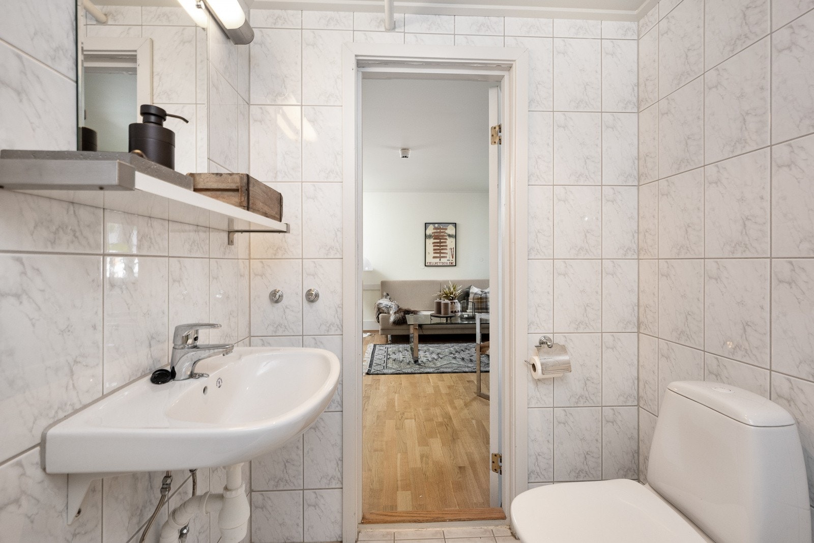 Badet er utstyrt med badekar, vegghengt vask i porselen med etgrepsarmatur og et gulvmontert toalett. Galleribilde