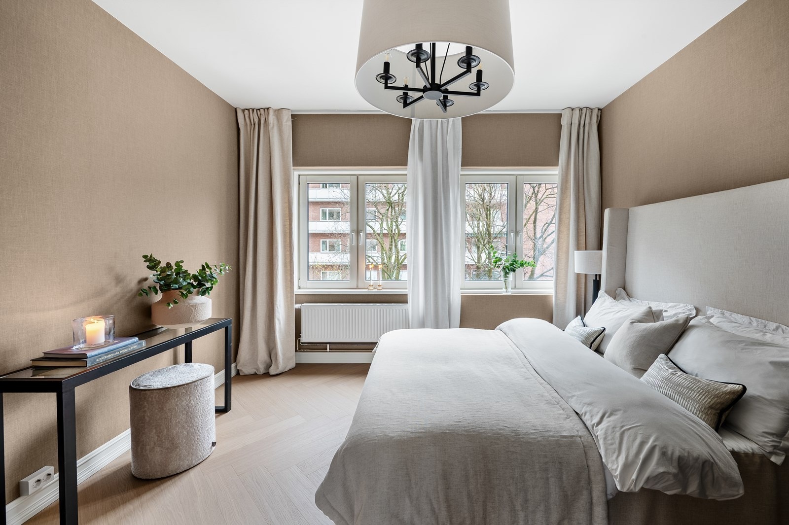 Rommet har en moderne tapet på veggene og fiske bensparkett på gulv. Galleribilde