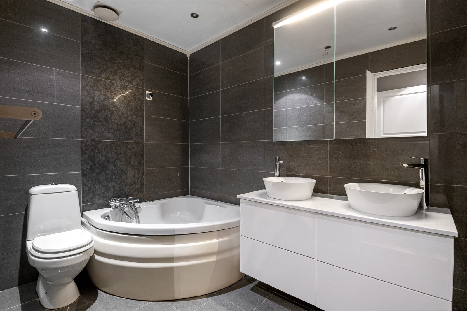 Romslig flislagt baderom fra 2009 med badekar og varme i gulv. Galleribilde