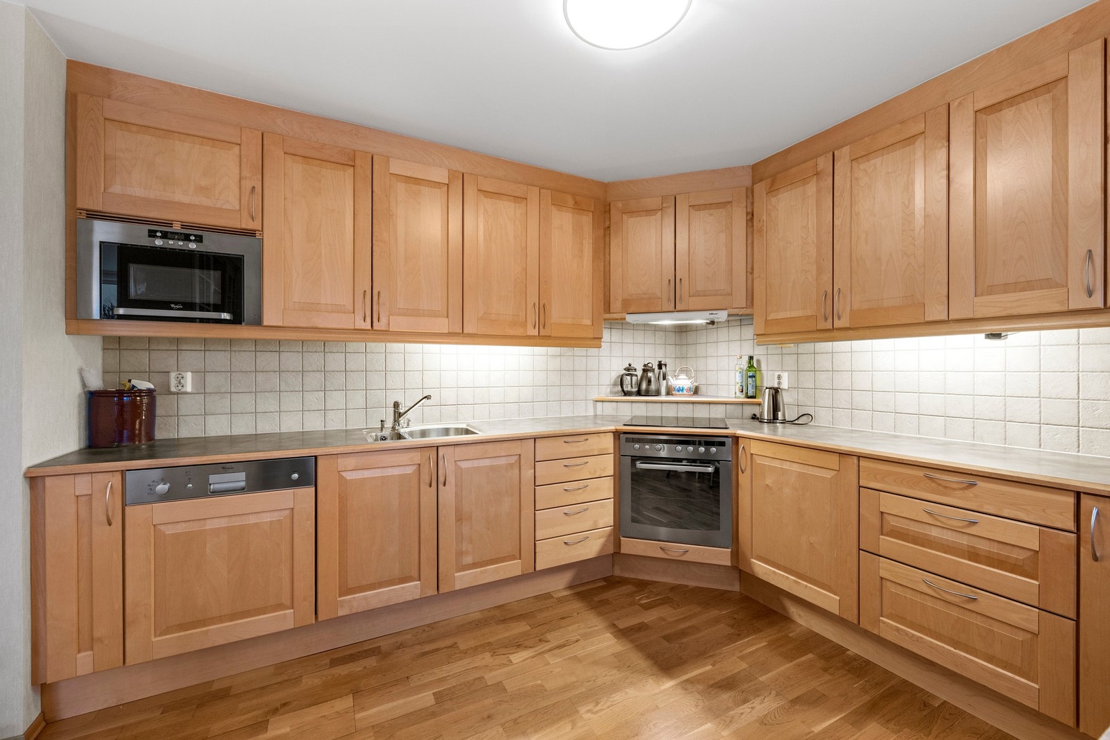 Pen og praktisk kjøkkeninnredning med integrerte hvitevarer Galleribilde