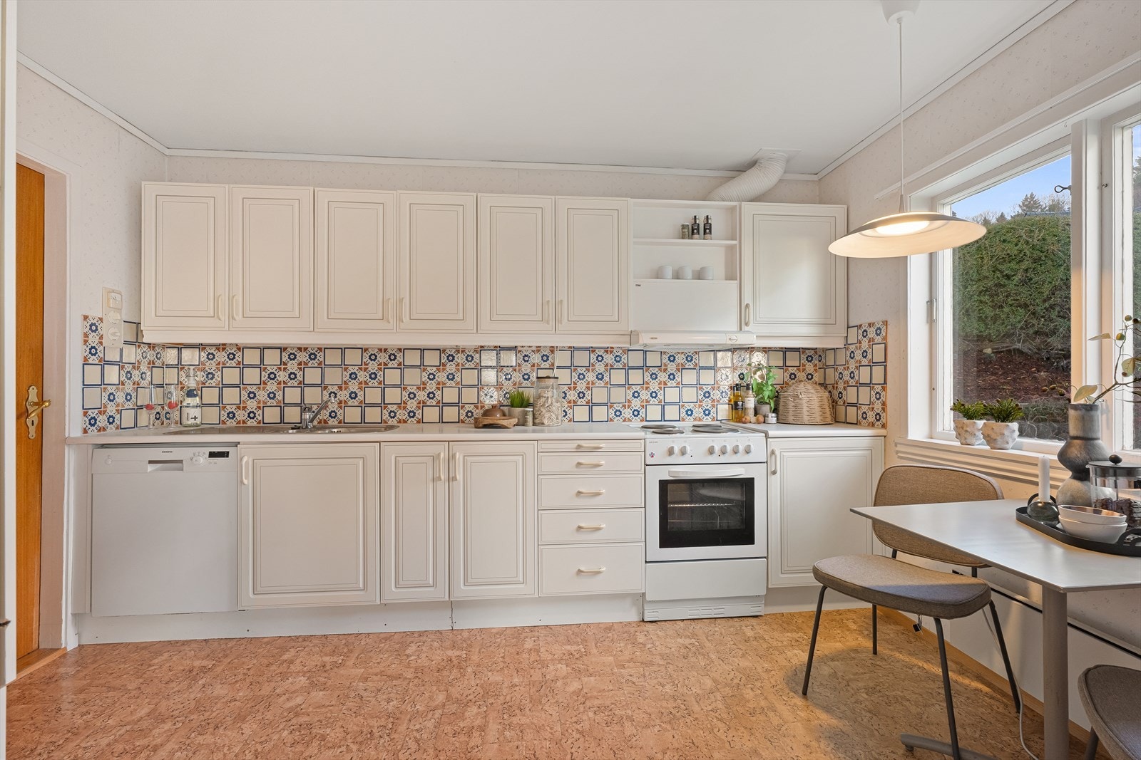 Koselig kjøkken med plass til spisebord. Det er skyvedør fra kjøkken inn til spisestuen/stuen. Galleribilde