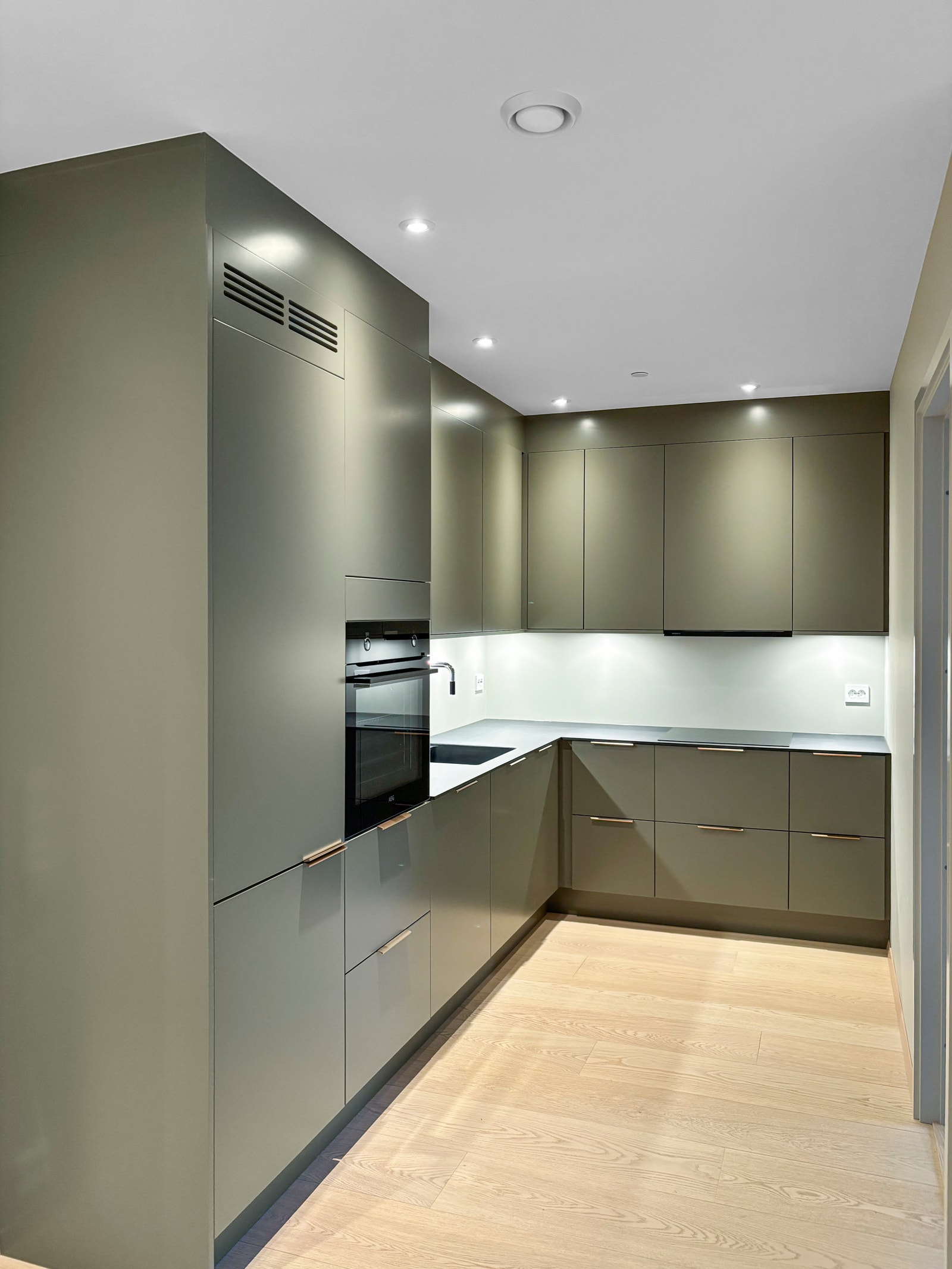 Kjøkkenet er moderne med slette fronter og integrerte hvitevarer. Galleribilde