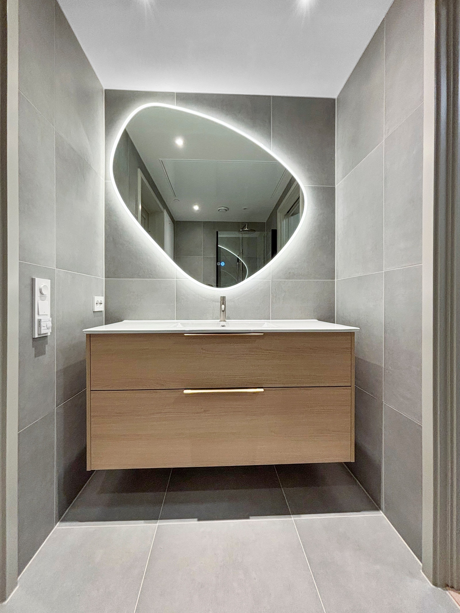 Badet har moderne baderomsinnredning og et pent speil med lys. Galleribilde