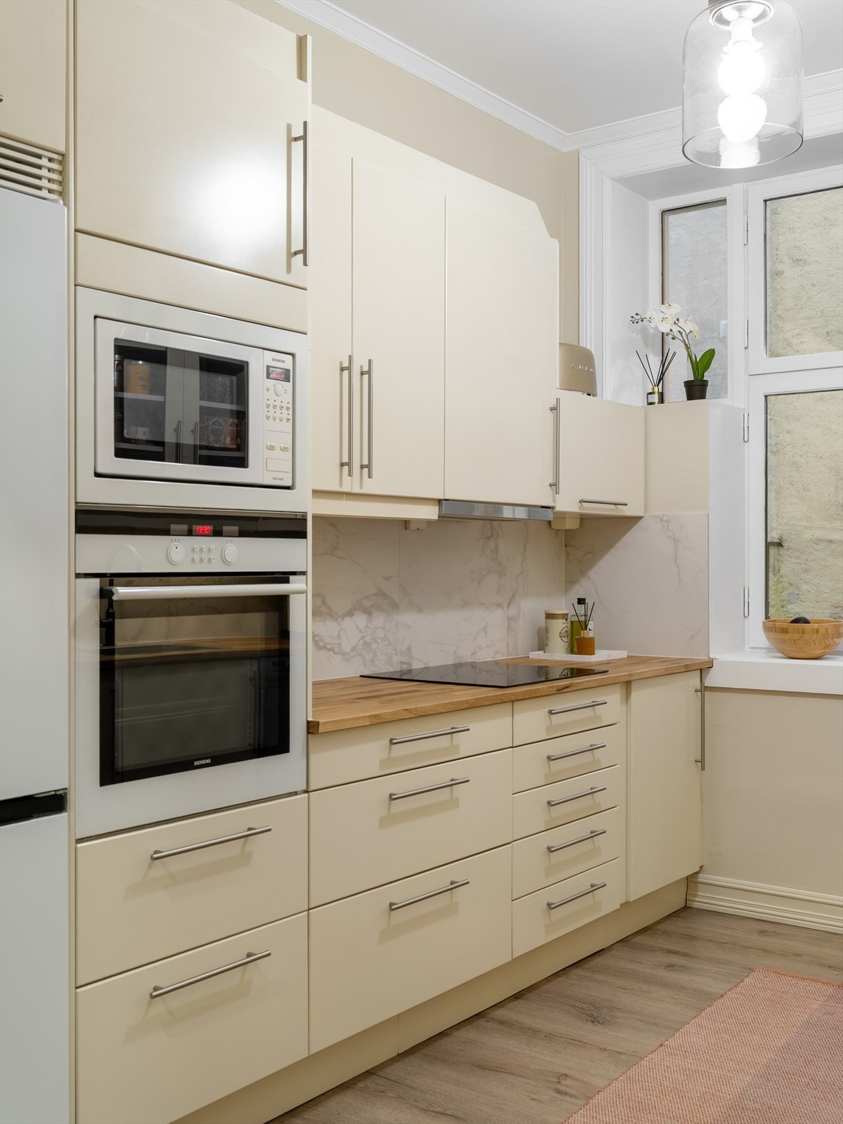 Innredning med vifte over stekesonen og opplegg for oppvaskmaskin. Det er integrert stekeovn, mikroovn og platetopp Galleribilde