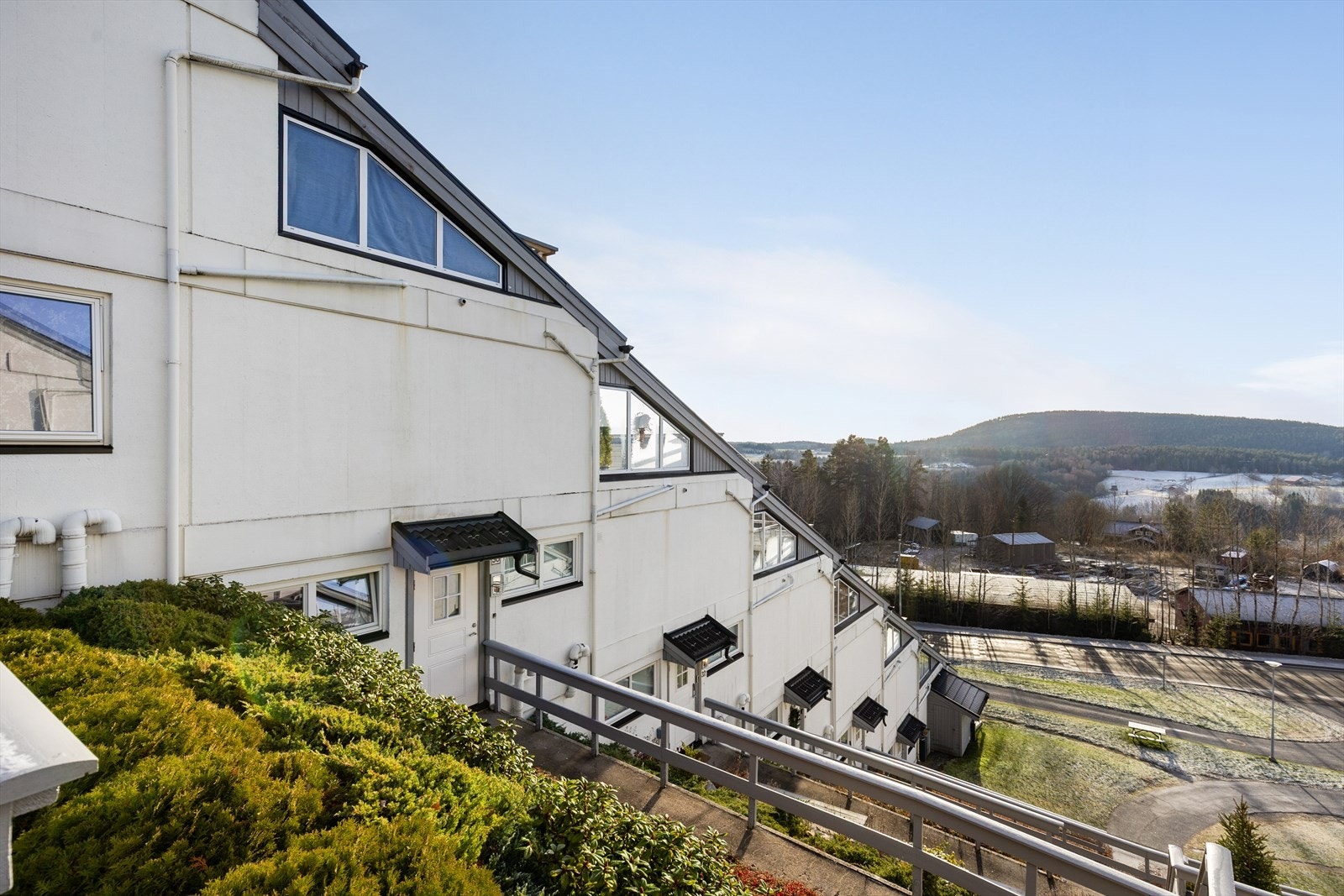 Det er etablert utvendige trapper på begge sider av bygget, med flott beplantning på hvert nivå. Galleribilde