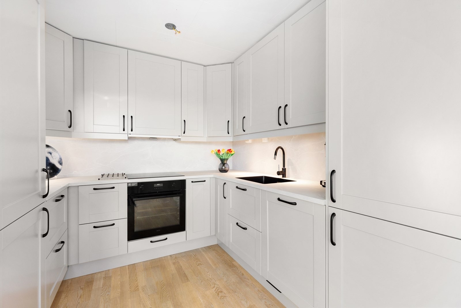 Det er gode arbeidsflater på laminerte benkeplater og godt arbeidslys under overskapene. Kjøkkenet har integrerte hvitevarer som oppvaskmaskin, koketopp, stekeovn og kjøleskap, og over kokesonen er det ventilator med avtrekk ut. Galleribilde