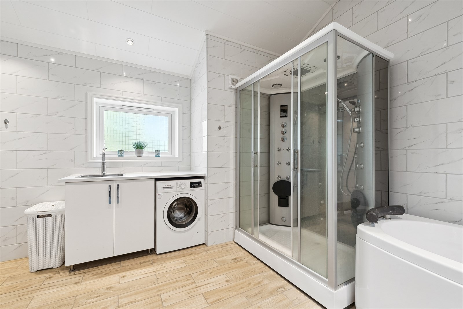 Stort bad/vaskerom med varmekabler og spotter i tak. Galleribilde