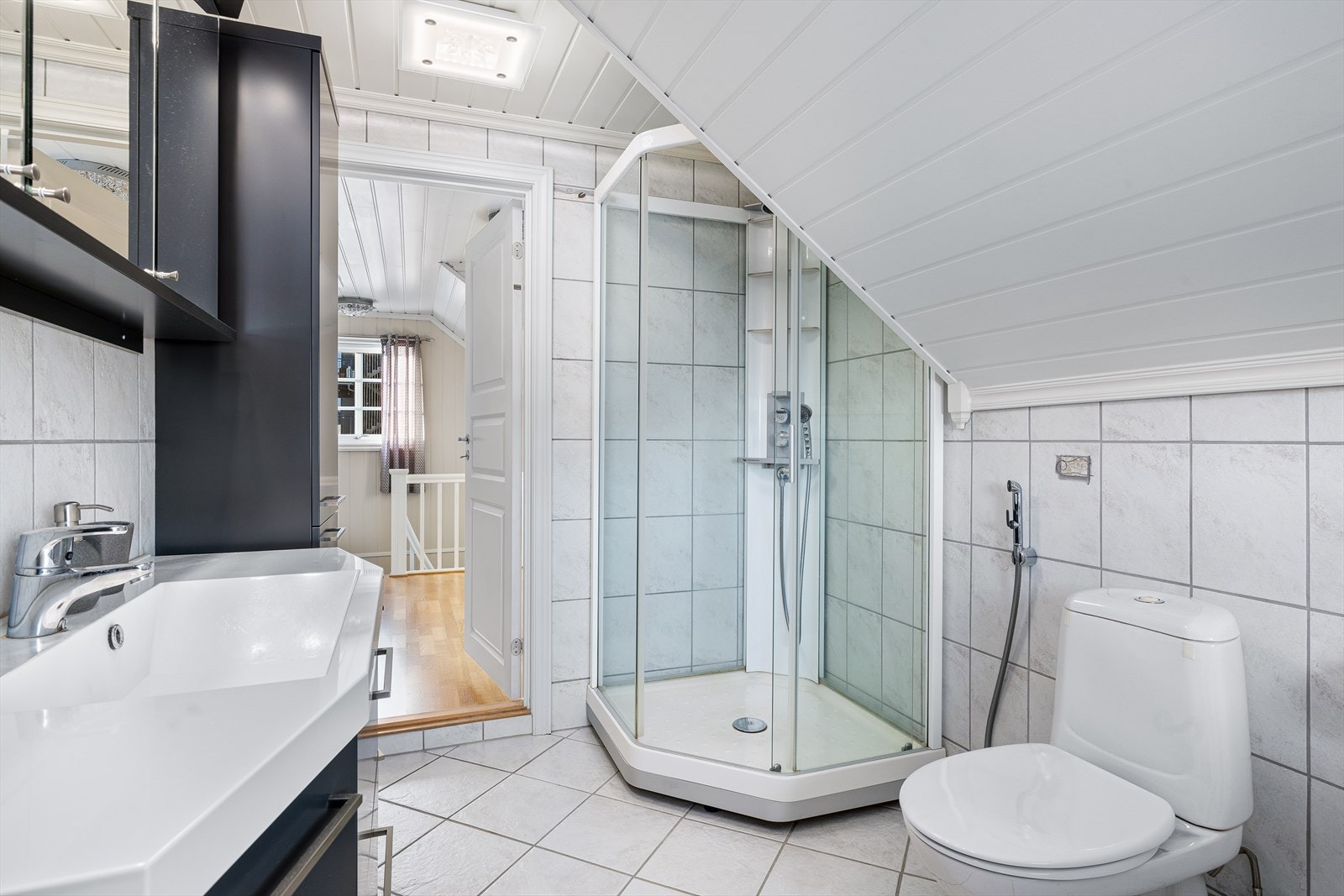 Rommet har innredning med nedfelt servant, kabinett, speilskap, 2 høyskap, klosett og opplegg til vaskemaskin Galleribilde