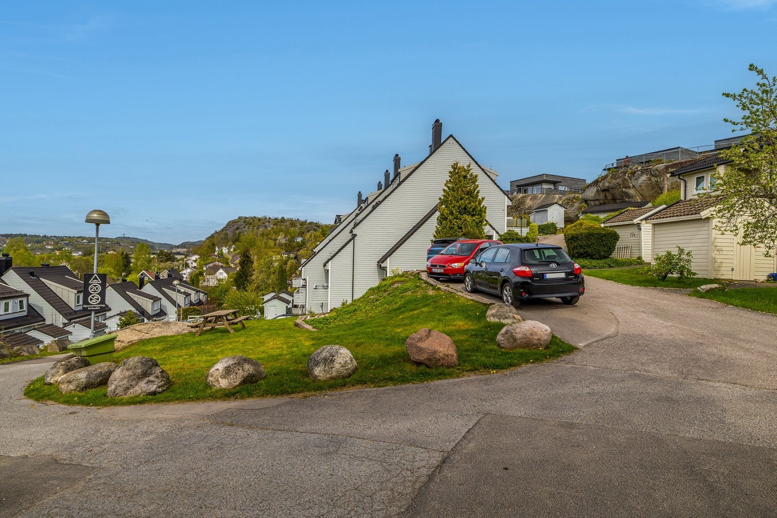 Pent opparbeidet tomt med asfalterte adkomstveier og parkeringsplasser. Beplantet med gressplen og diverse prydvekster. Galleribilde