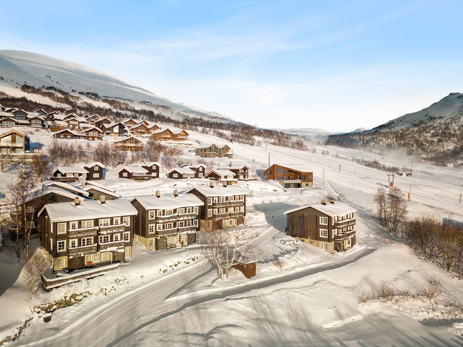 Fellestomten er skrånende, med naturlig vegetasjon, støttemurer i naturstein og gruslagte internveier. Galleribilde