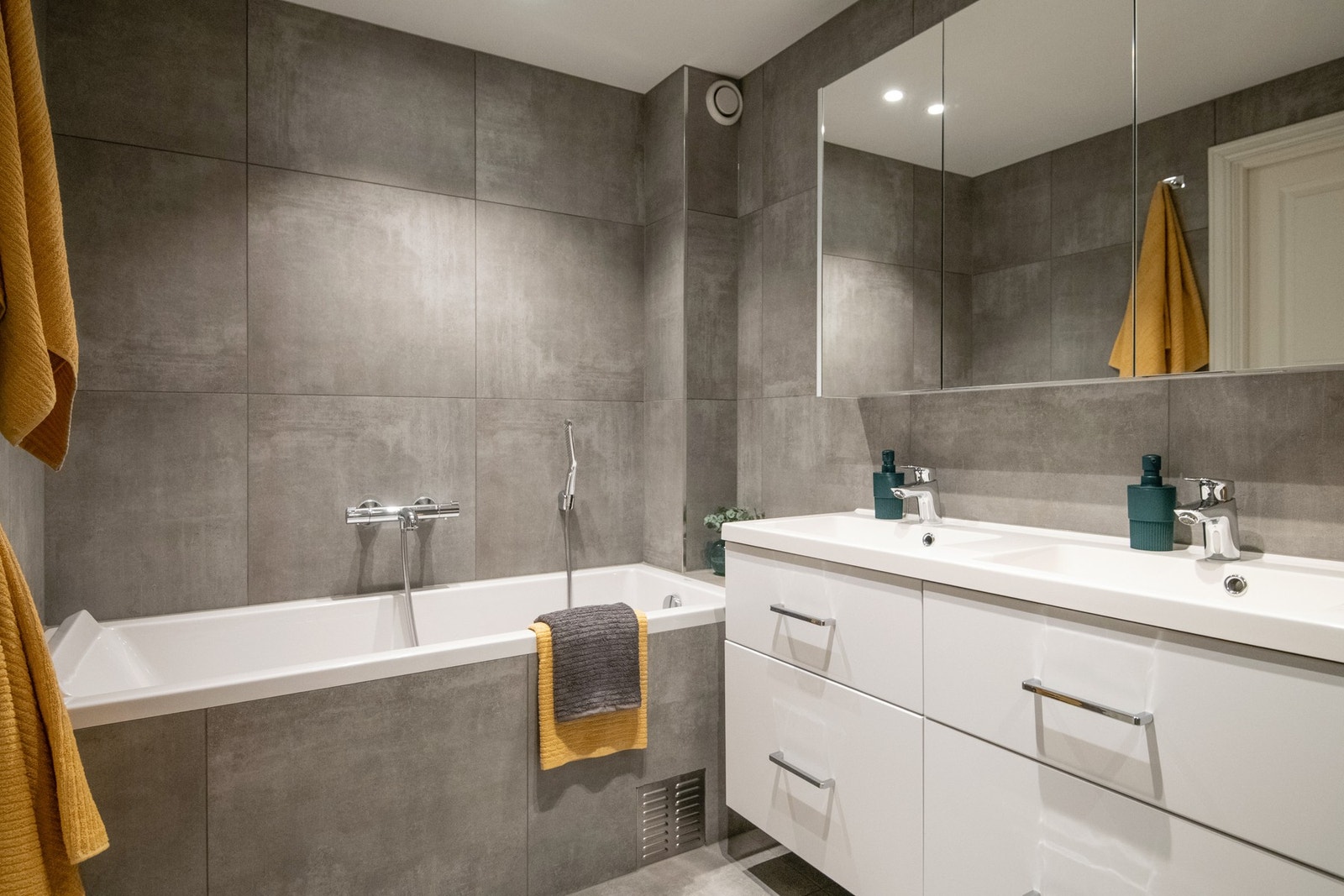 Med flislagte overflater, gulvvarme, innfliset badekar, dusj med innfellbare dører i herdet glass og dobbel servant, får du en eksklusiv spa-følelse i hverdagen. Galleribilde