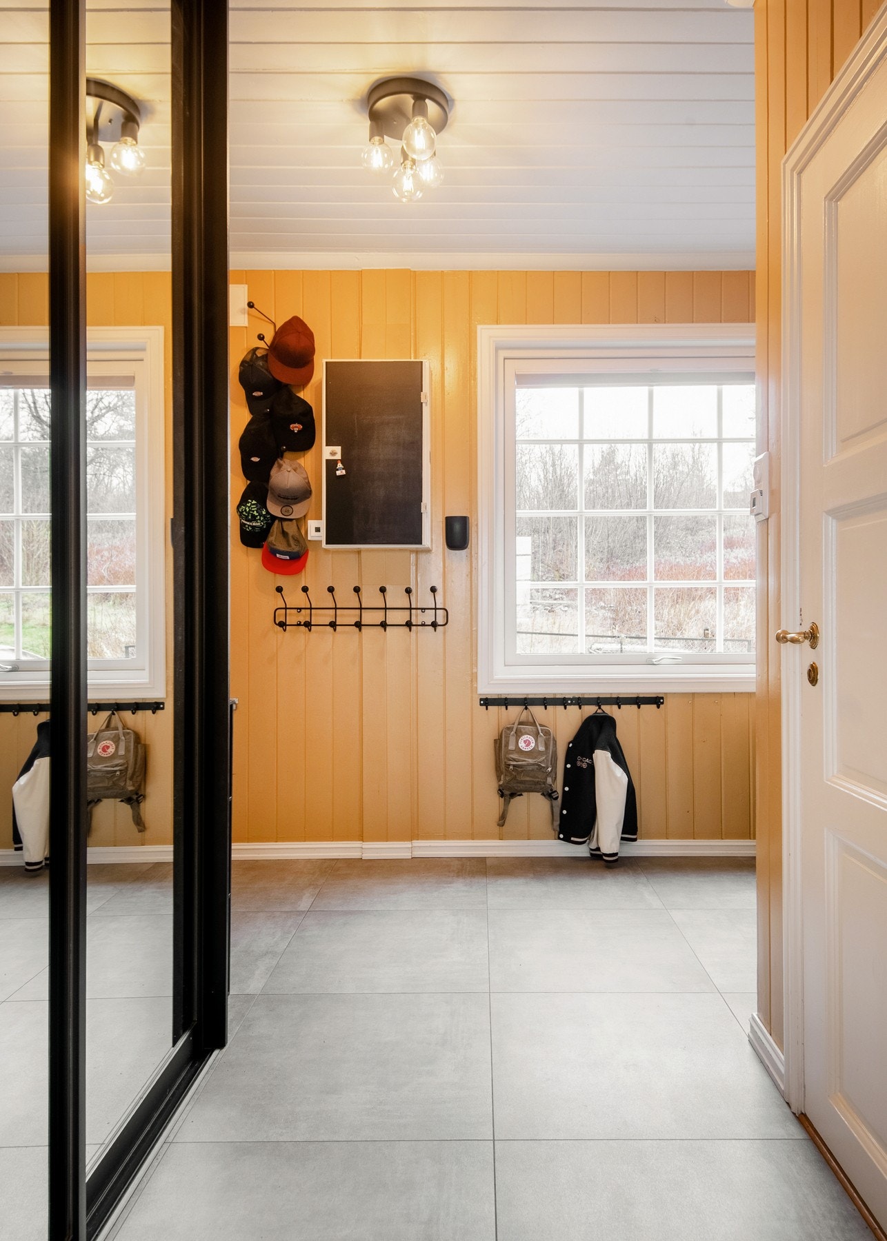 Boligen ønsker deg velkommen gjennom en romslig og innbydende entré med flislagt gulv med varme - et praktisk og stilrent valg. Galleribilde