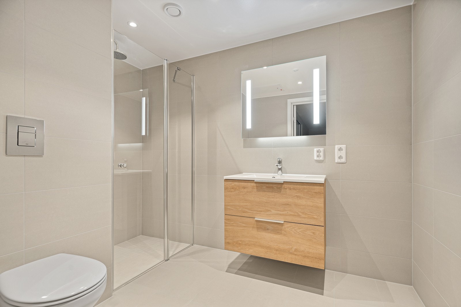 Pent flislagt bad i beige utførelse med varme på gulvet Galleribilde