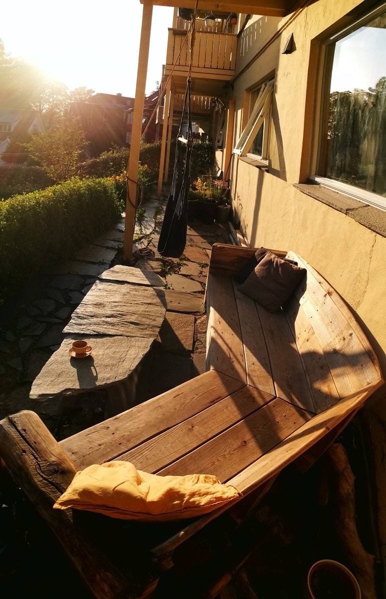 Koselig og lun uteplass med plassbygd utesofa Galleribilde