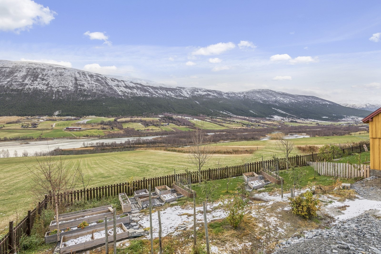 Fin utsikt omgitt av idylliske fjell og frodige landbruksarealer. Galleribilde