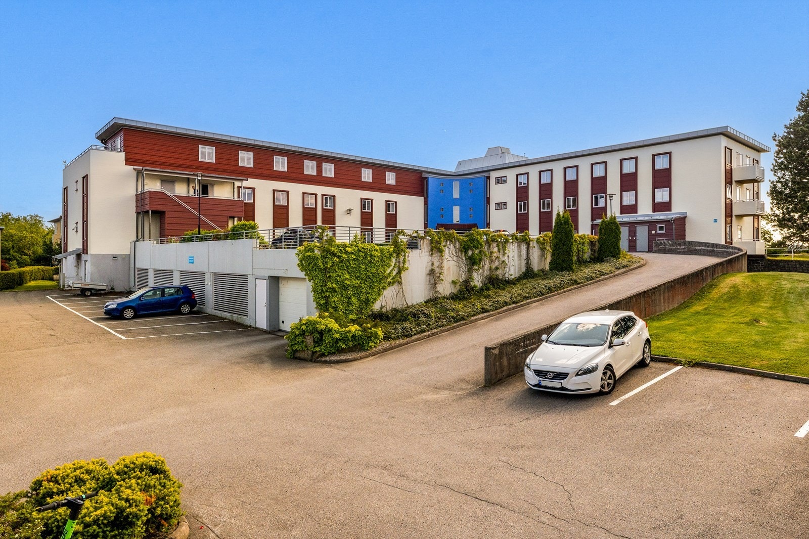 Sameiets uteområde er trivelig og velholdt, med grønne omgivelser som skaper en innbydende atmosfære. I tillegg er det praktisk tilrettelagt med adkomst til garasjekjelleren, som gjør parkering både enkel og tilgjengelig for beboerne. Galleribilde