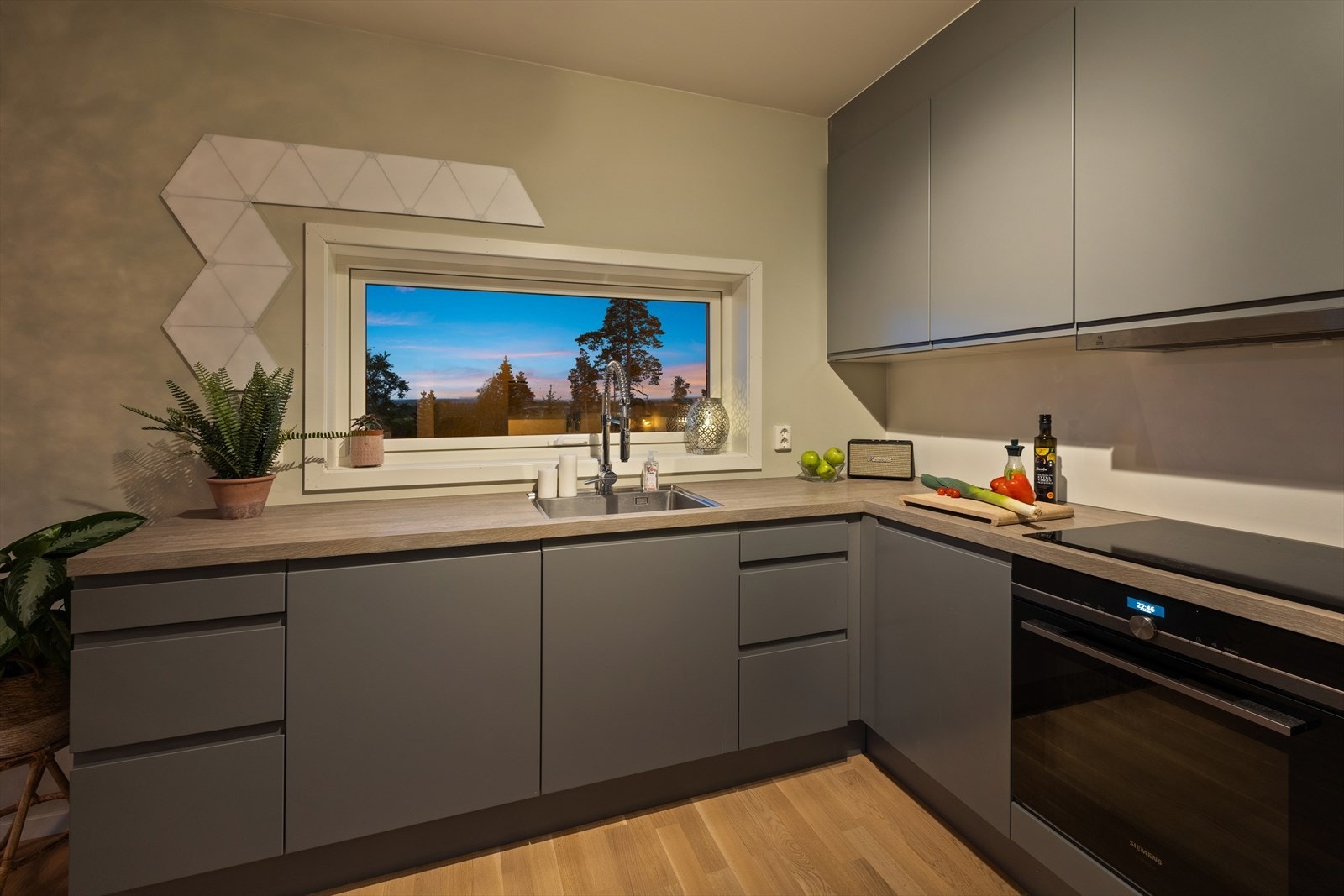 Stilren kjøkkeninnredning med integrerte hvitevarer. Legg merke til vindu som gir en hyggelig syn ved matlagningen! Galleribilde