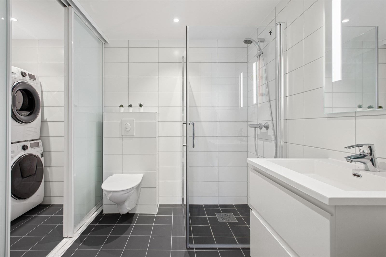 Badet i underetasje er praktisk designet med en skyvedør som skiller mellom tekniske rommet og badet. I det tekniske rommet er det opplegg for vaskemaskin og tørketrommel i søyle. Galleribilde