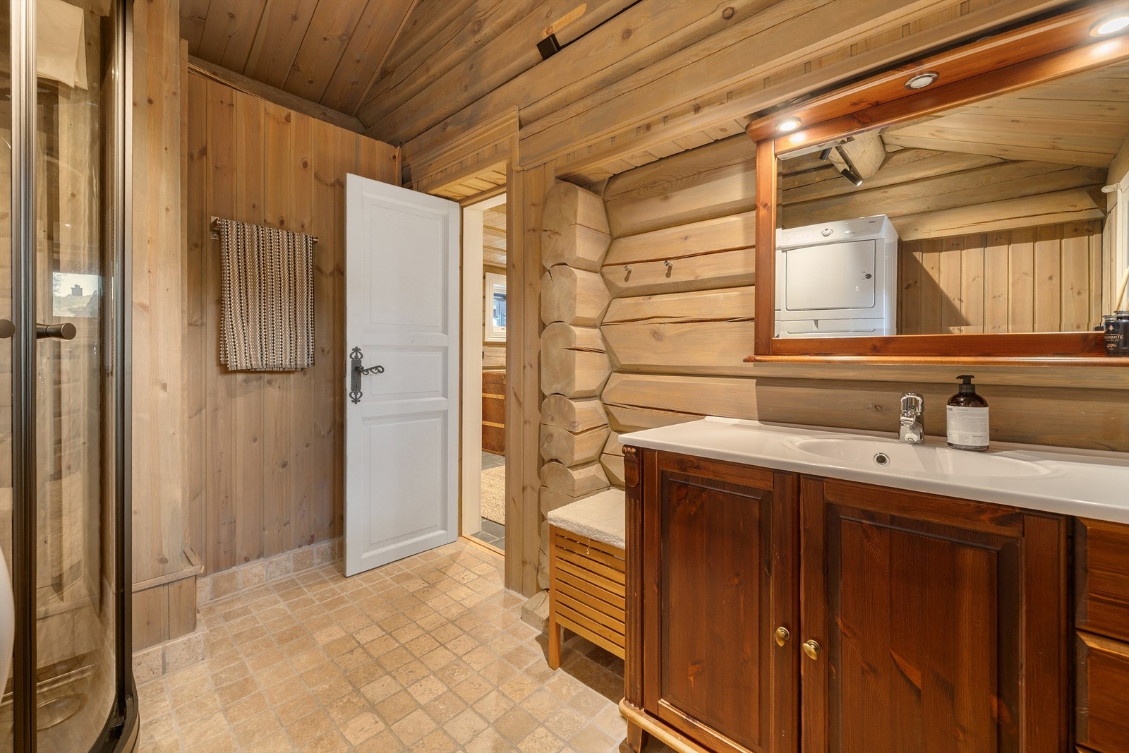 Bad med dusjhjørne, wc og servant med skuffer og skap under. Opplegg vaskemaskin. Galleribilde