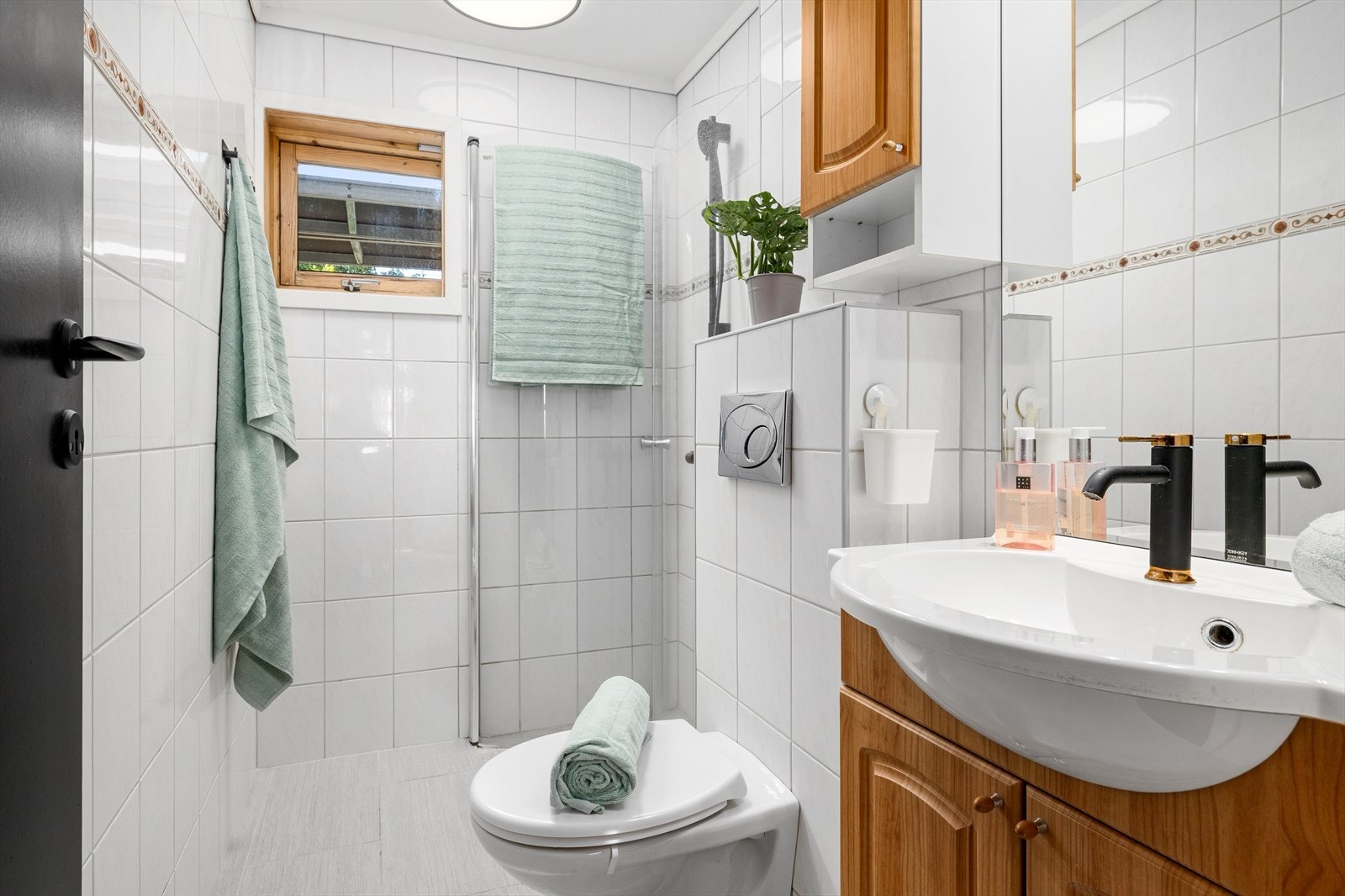 Flott fliselagt bad med vegghengt wc, dusjnisje og servant i innredning. Varme i gulv. Galleribilde