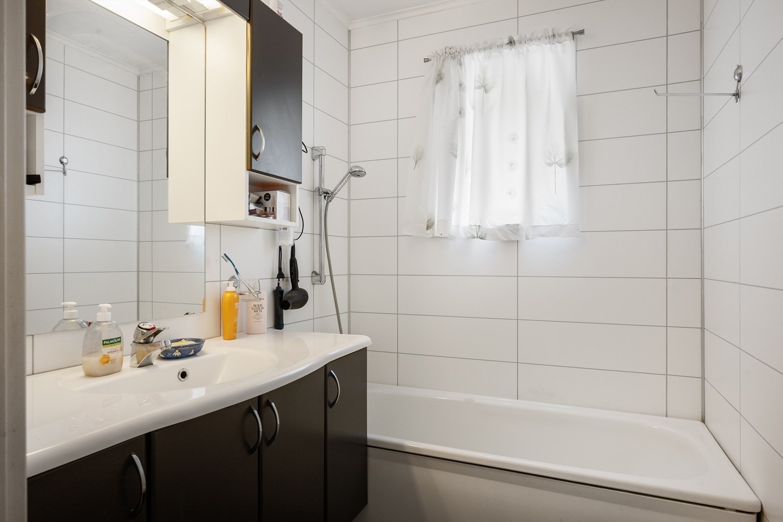 Badet har lyse våtromsplater på vegg og belegg på gulv - det er ett bad i hver etasje. Galleribilde