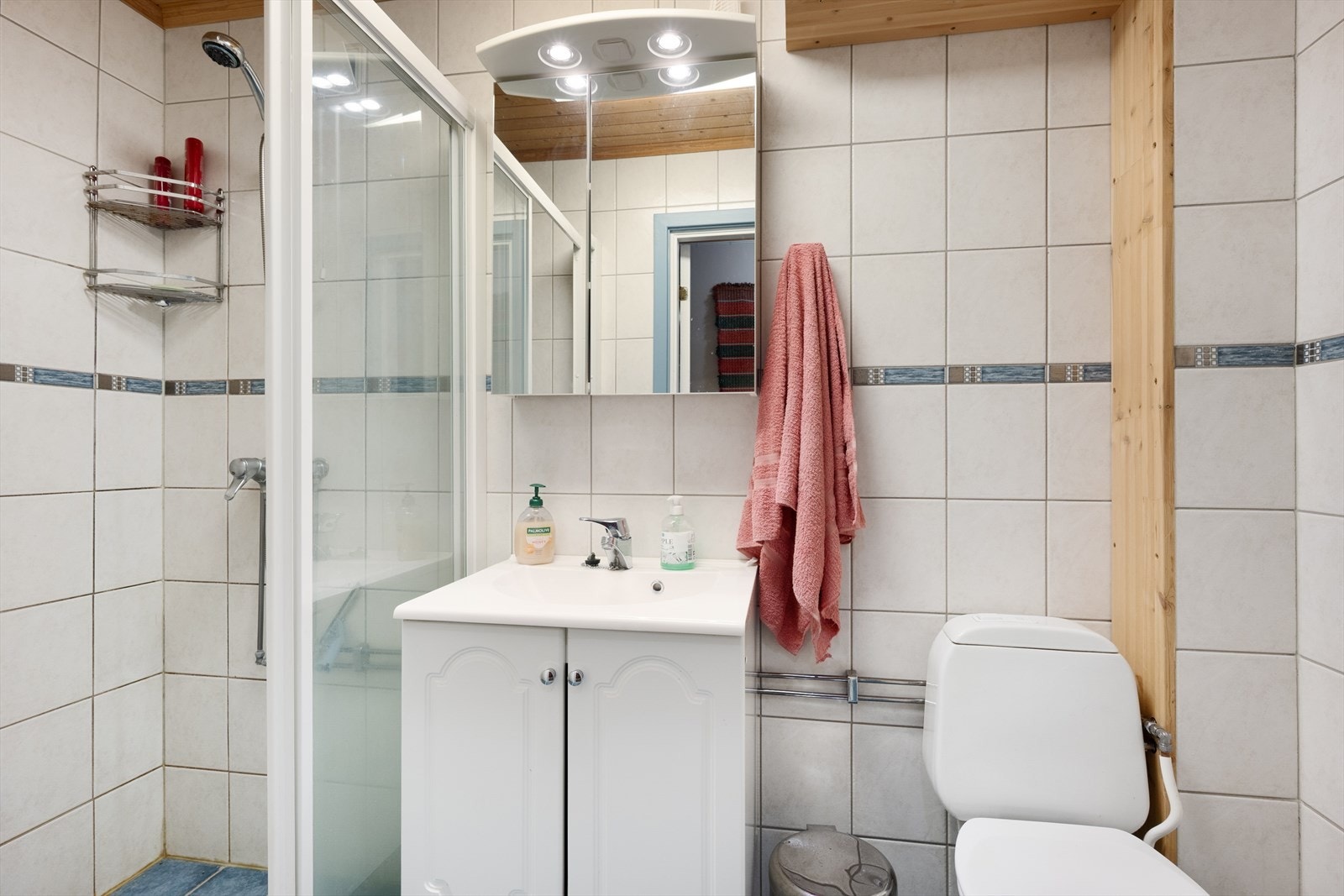 Badet i kjelleretasjen har flislagte overflater og er innredet m/skapinnredning, dusjvegger og gulvmontert wc. Galleribilde