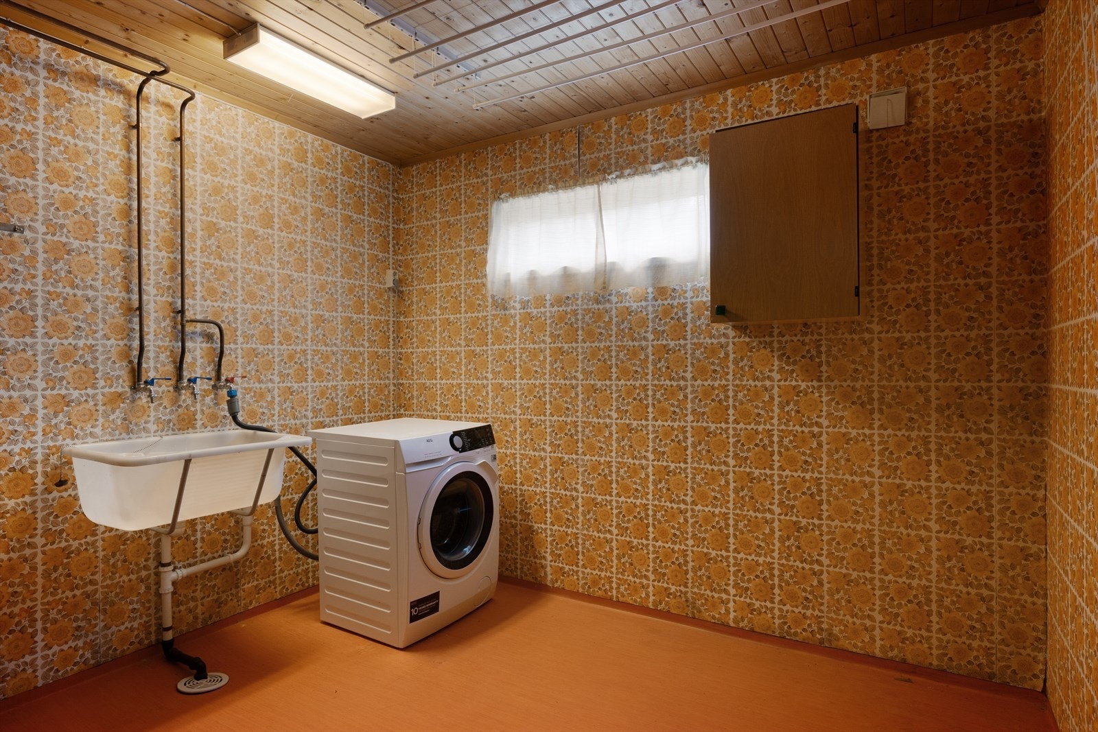 Vaskerommet er enkelt innredet med kum og opplegg for vaskemaskin. Galleribilde