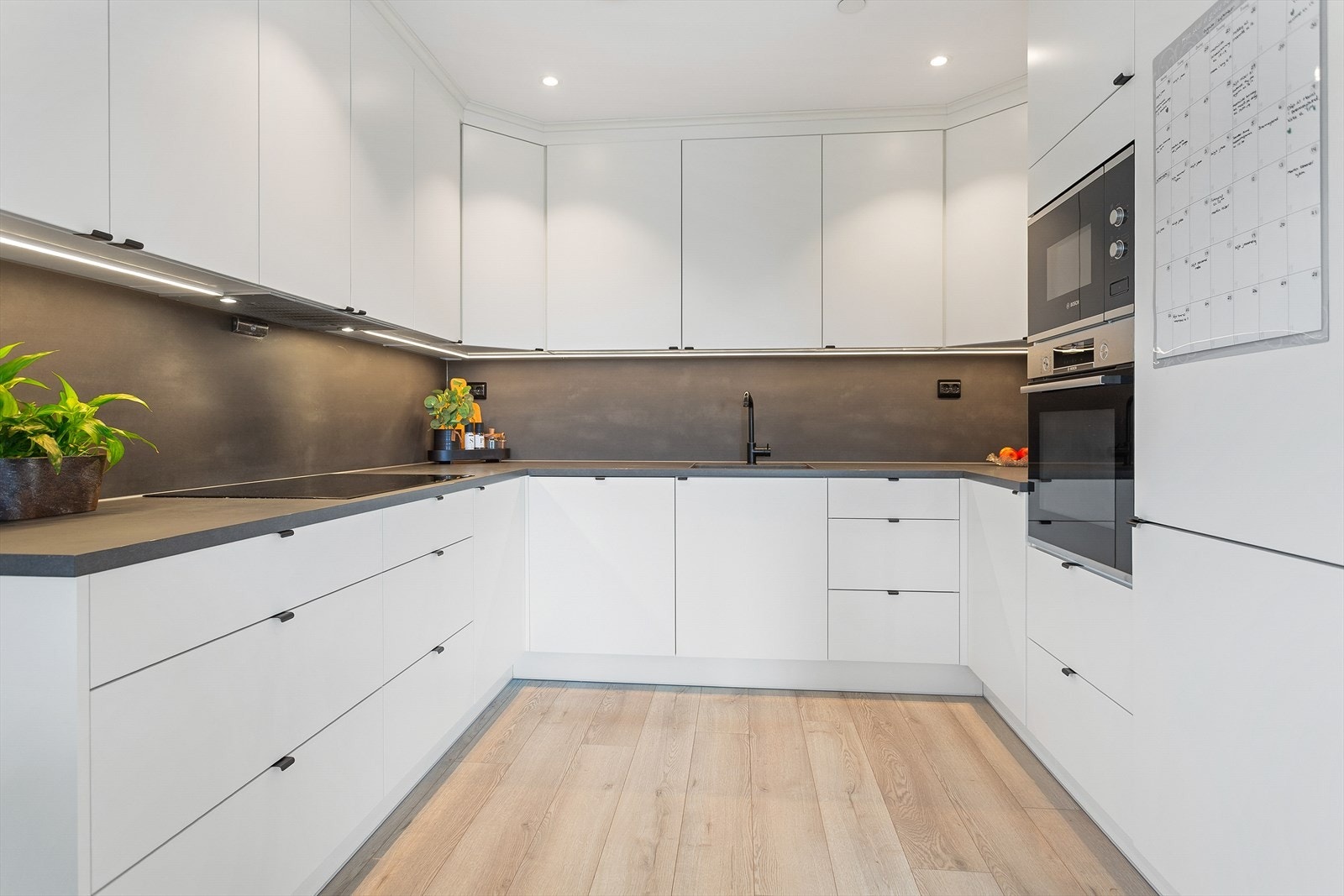 Integrerte hvitevarer og belysning over kjøkkenbenken Galleribilde