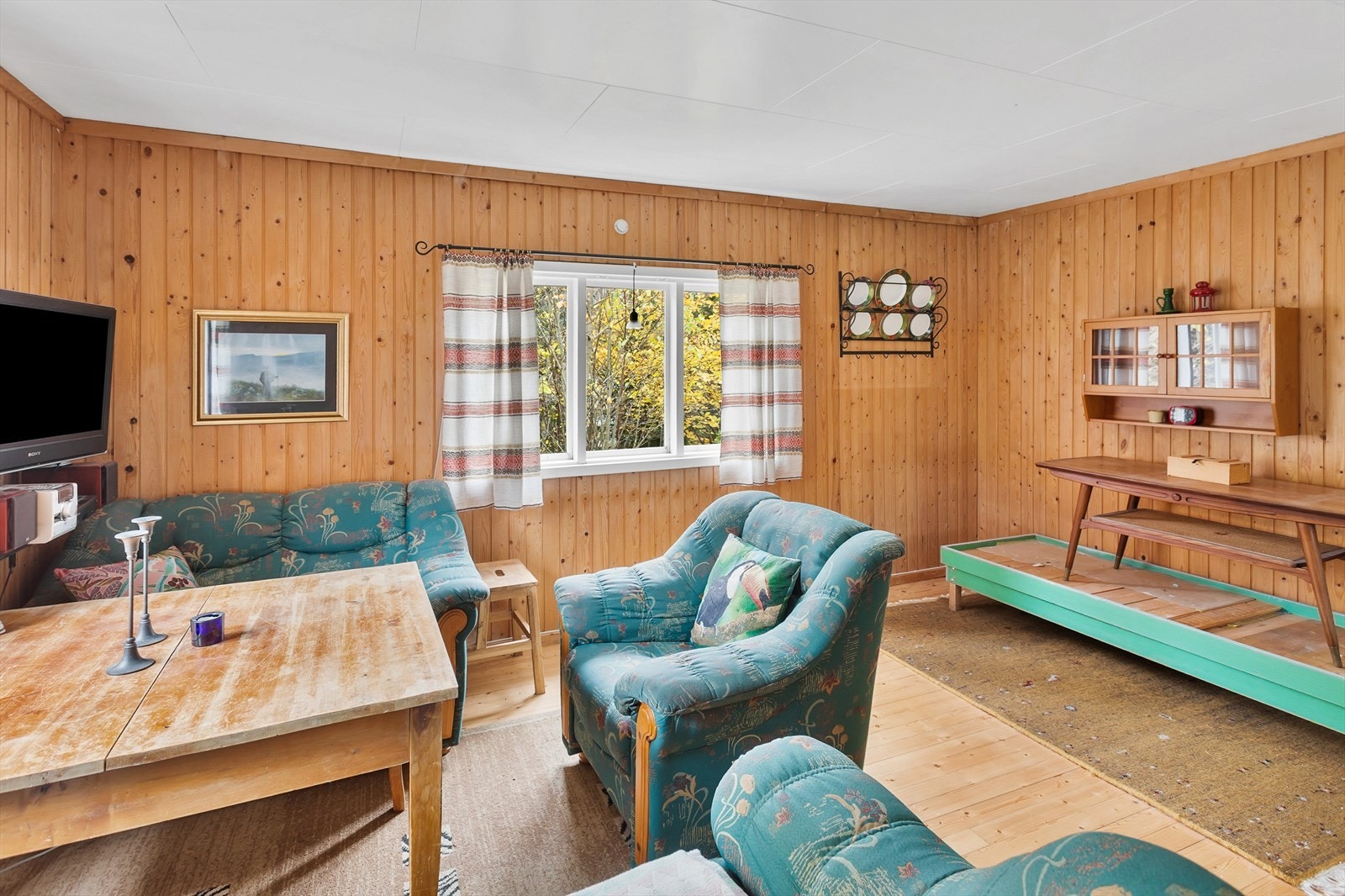 Store vinduer i stuen gir utsyn mot det grønne uteområdet. Galleribilde